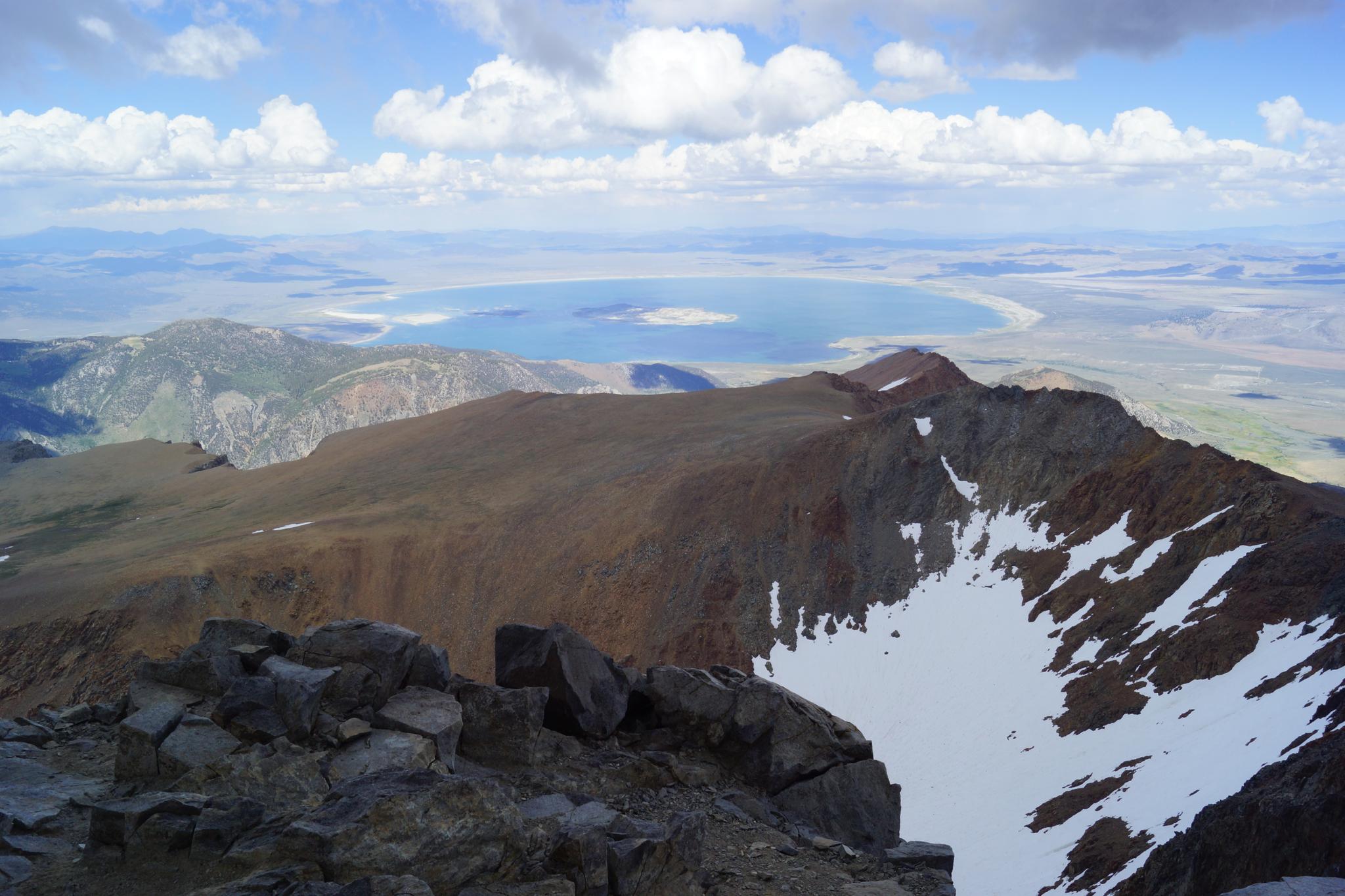 Panoramic view of rugged mountains, a large lake, and distant landscape.