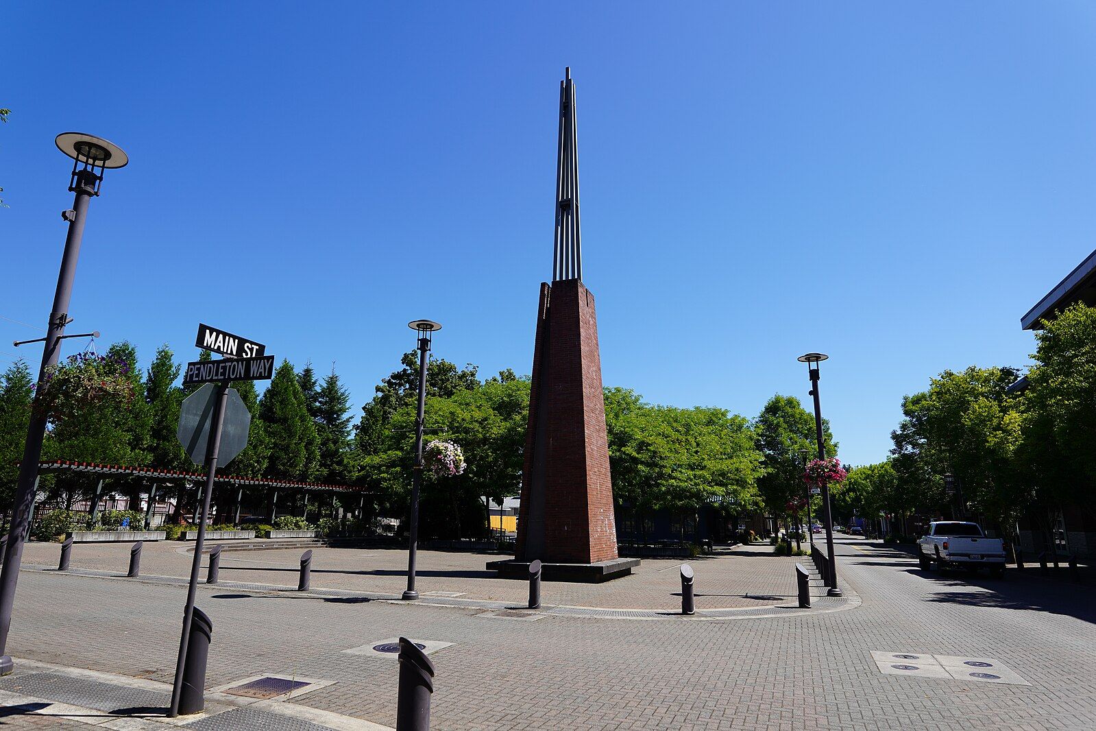 Tall brown monument in a paved town square under a clear blue sky. - Reflection Plaza – Washougal Waterfront Park loop from Washougal