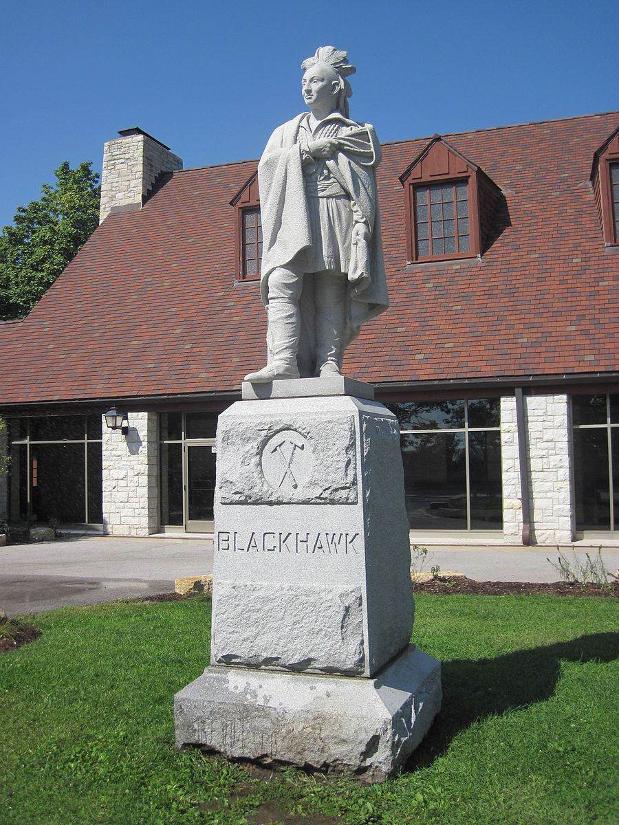 Stone statue of a person in traditional attire on a sunny day. - Black Hawk State Historic Site Loop