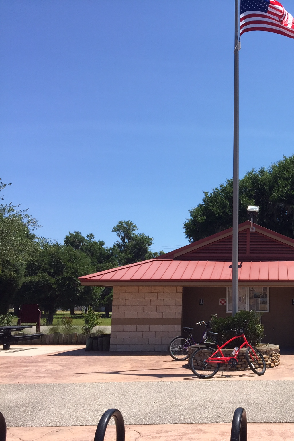 Sunny outdoor scene with a building, American flag, and two bicycles.