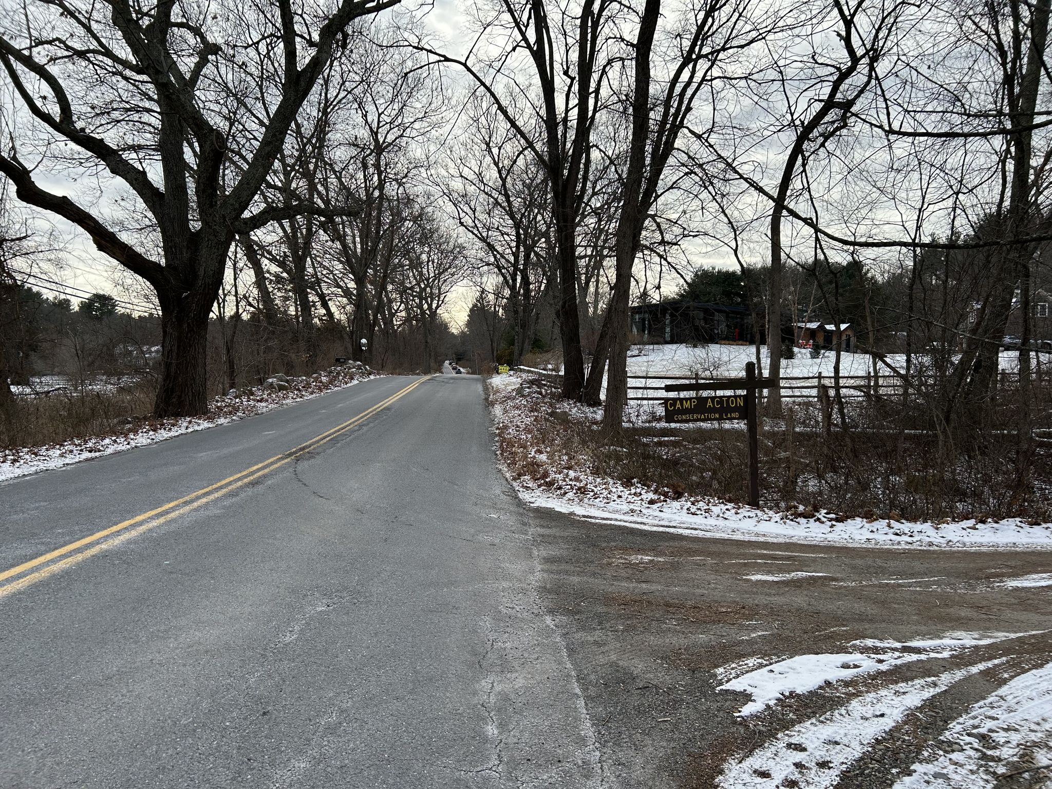 A quiet road with bare trees and light snow under an overcast sky. - Pope Road – Colonel Barrett House loop from Carlisle
