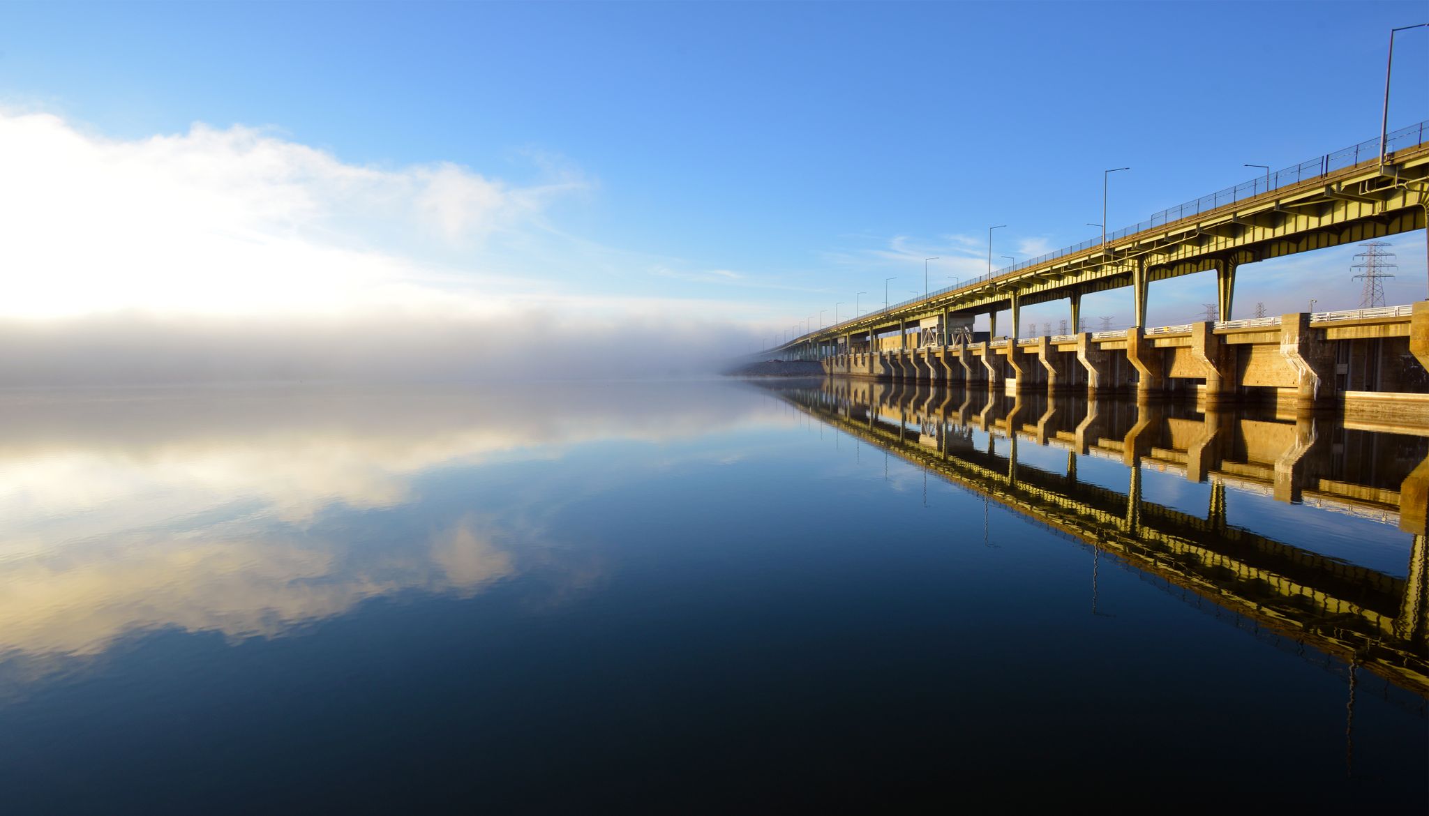 Long bridge over calm water reflecting blue sky and distant fog. - Bakewell Mountain & Chickamauga Reservoir loop