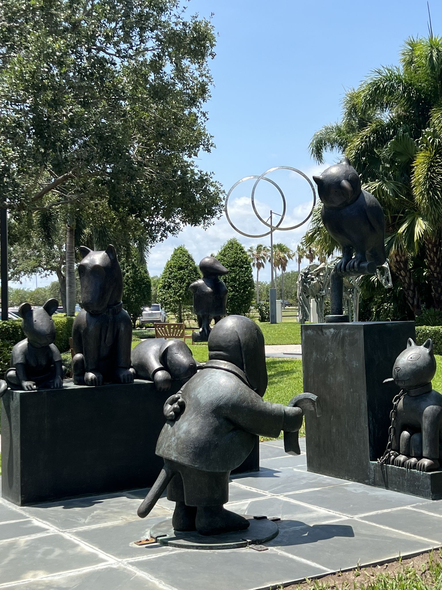 Dark cartoon animal statues arranged outdoors on a bright, sunny day. - Riverside North Park – Riverside North Park loop from Farley Island