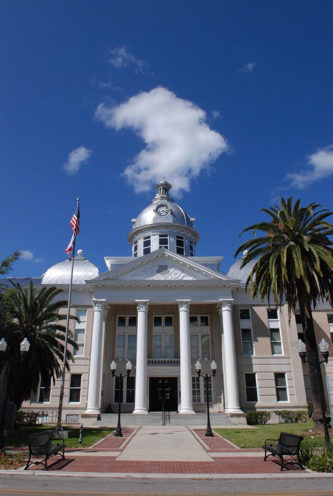 A grand building with a dome and columns under a bright blue sky.