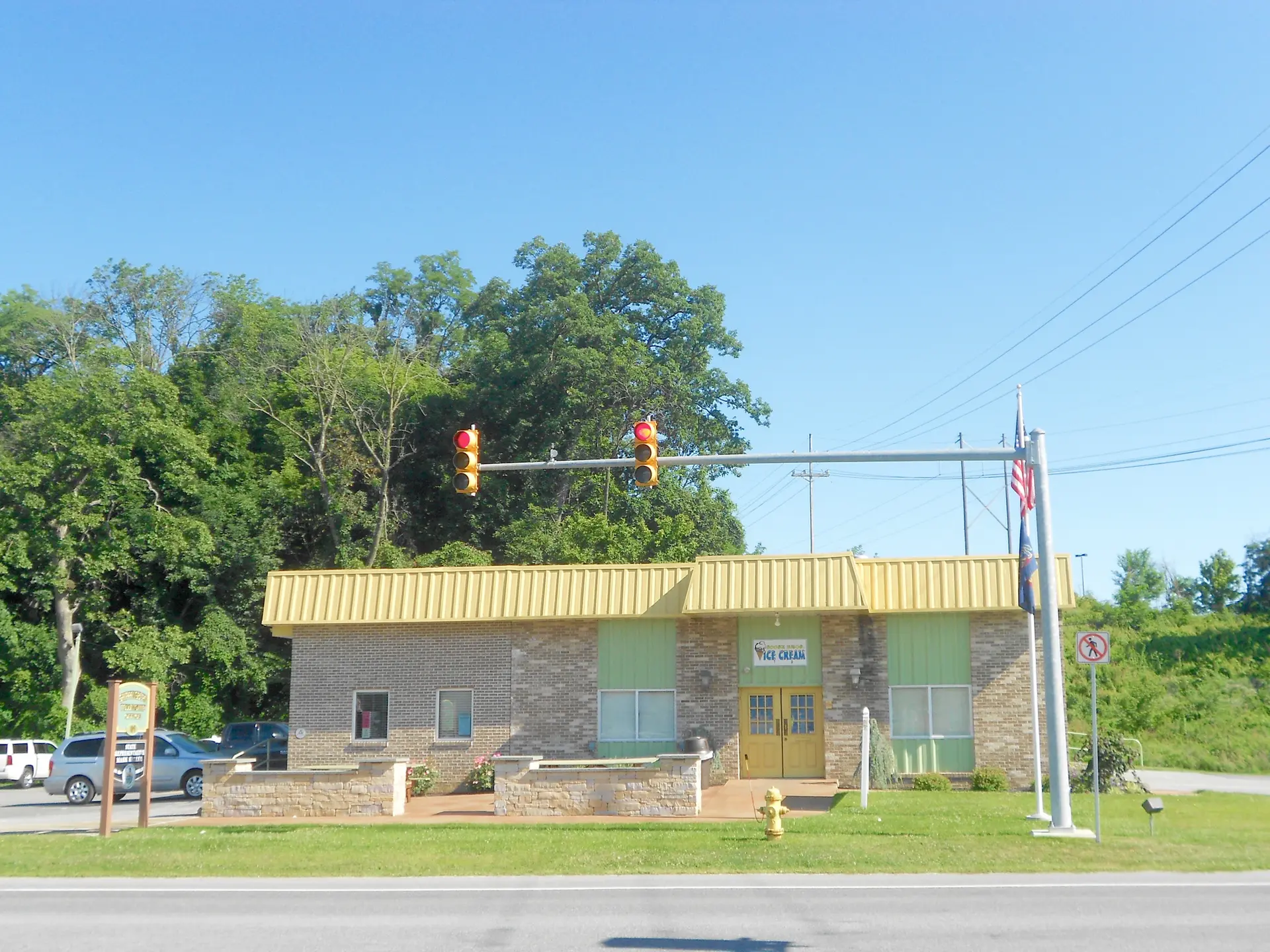 Brightly lit yellow and brick building with traffic lights under a clear sky.