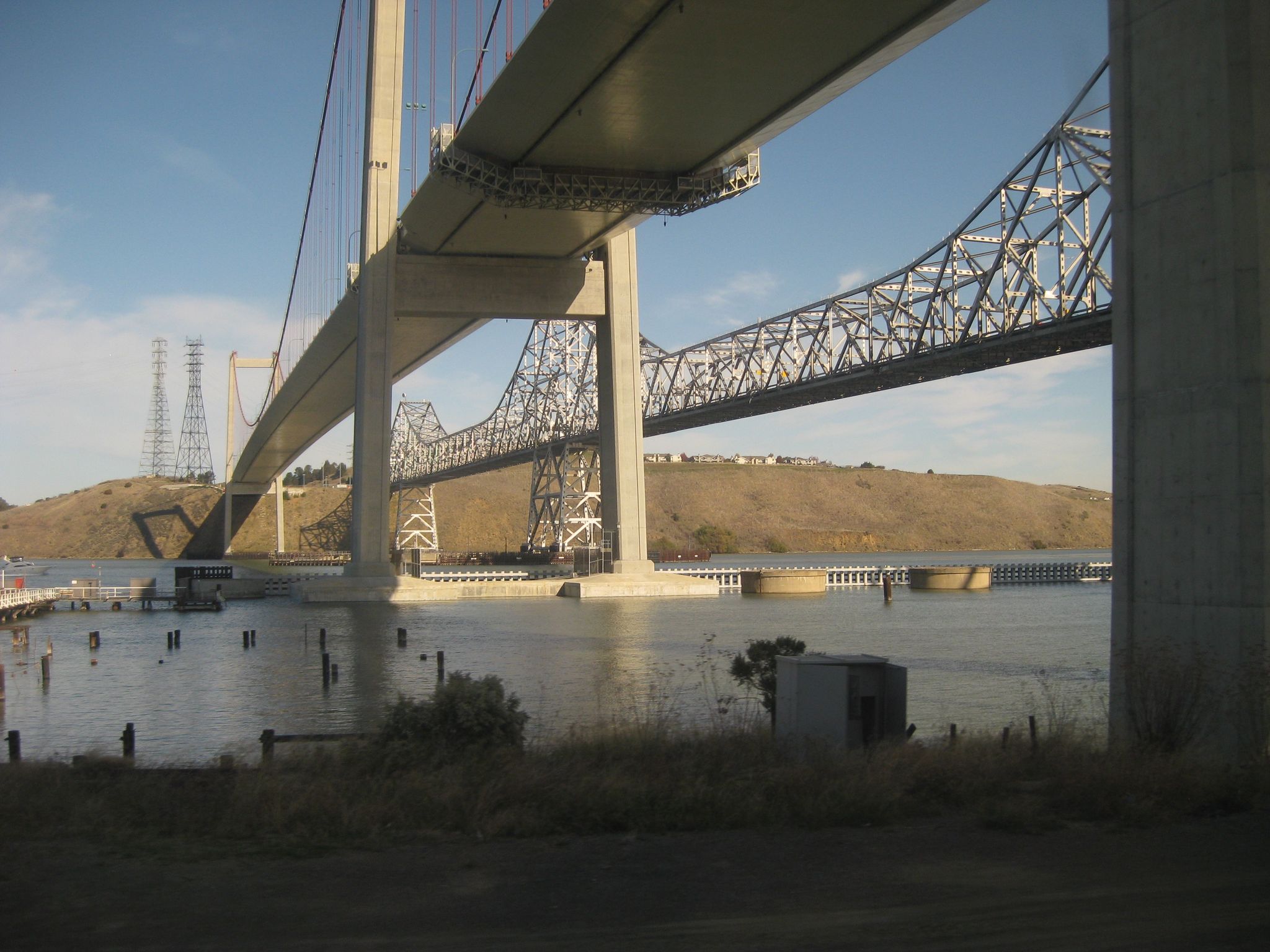 View beneath two large bridges spanning calm water and distant hills. - Bay Area Ridge Trail: Martinez City Streets