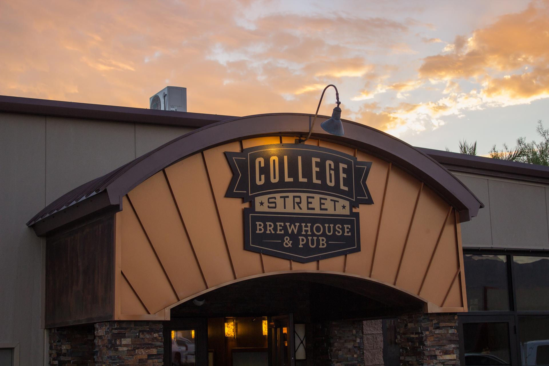 Illuminated sign for "College Street Brewhouse & Pub" at sunset with warm clouds.