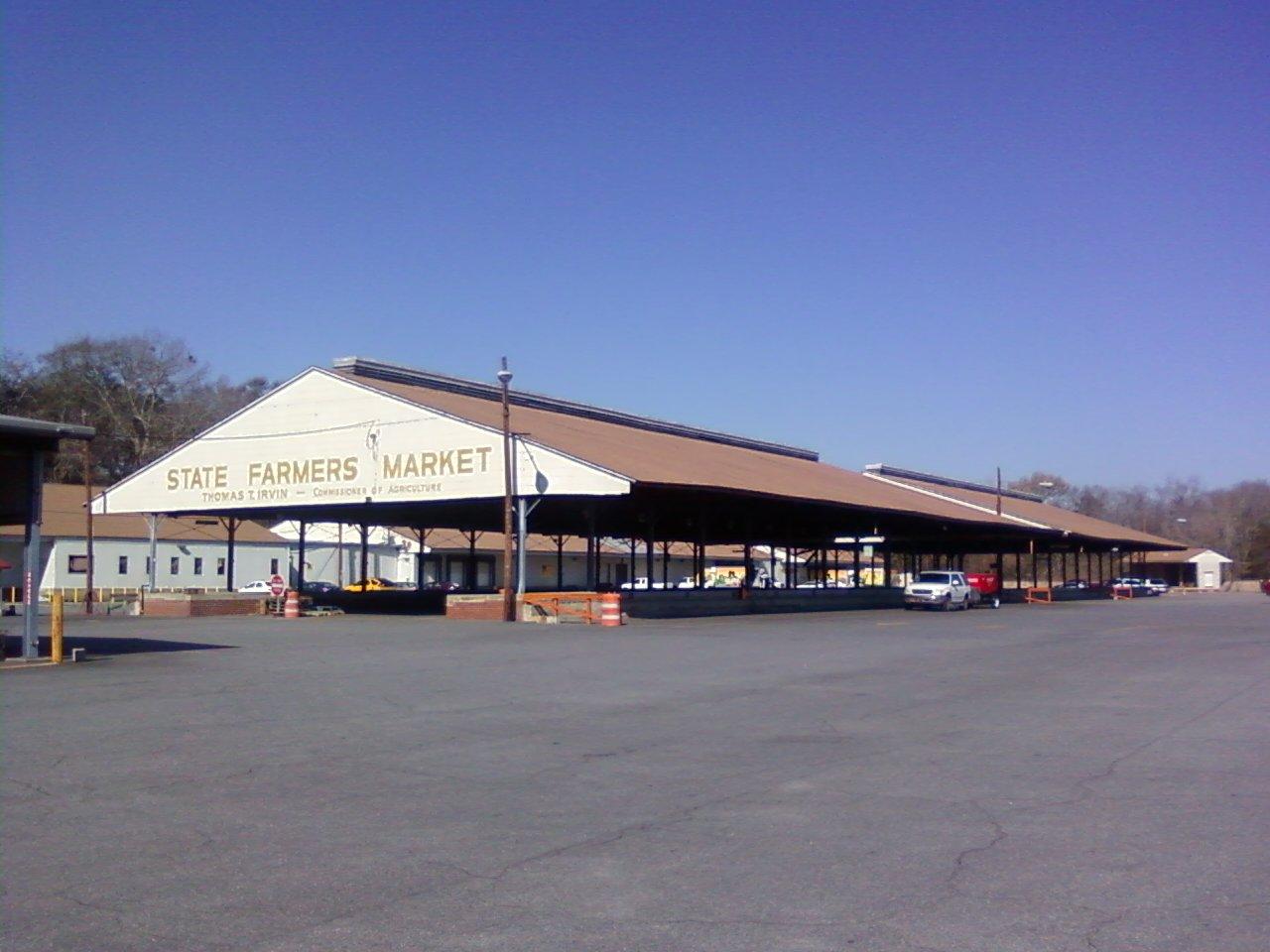 A large, open-sided market building under a clear blue sky.