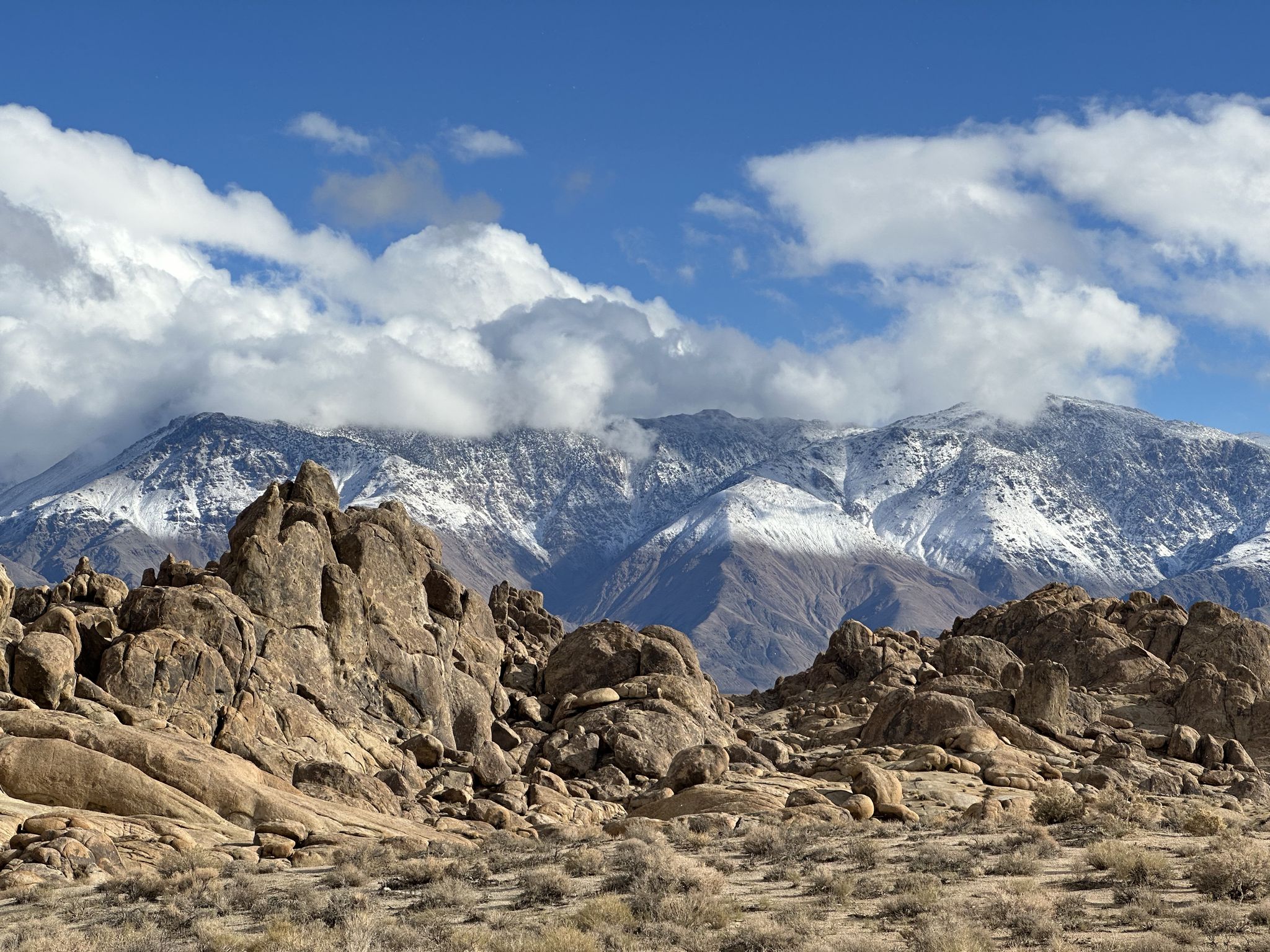 Rocky desert foreground with majestic snow-capped mountains under a cloudy sky. - Alabama Hills – Lone Pine loop from Lone Pine