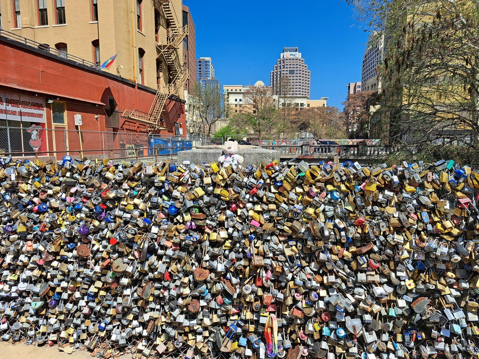 A fence completely covered with thousands of colorful love locks in an urban setting.