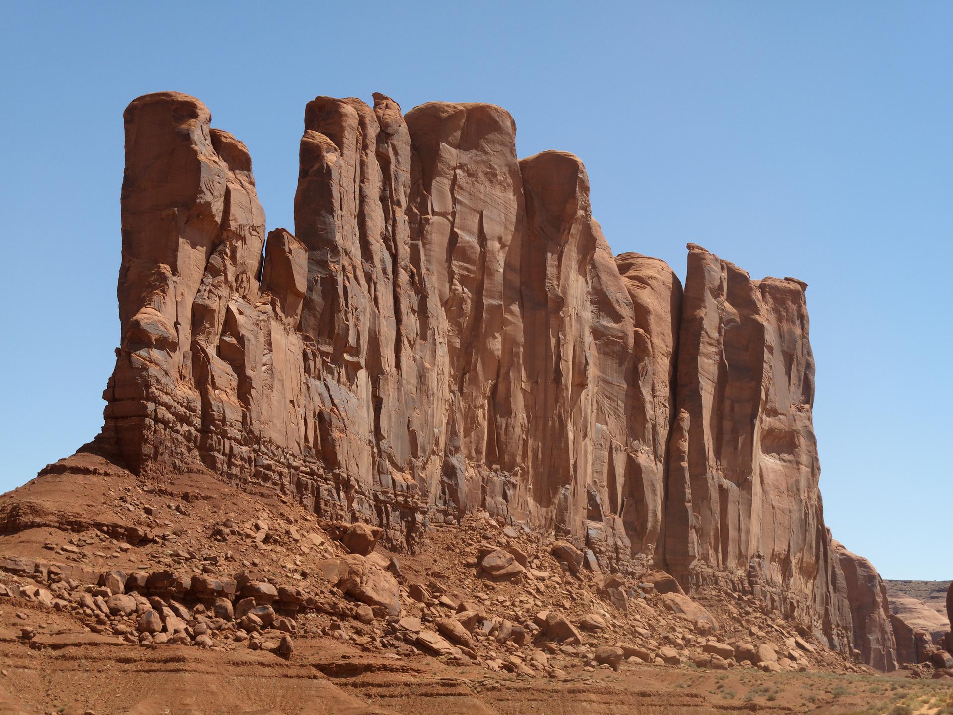 Close-up of towering red rock formations with vertical striations against a blue sky.