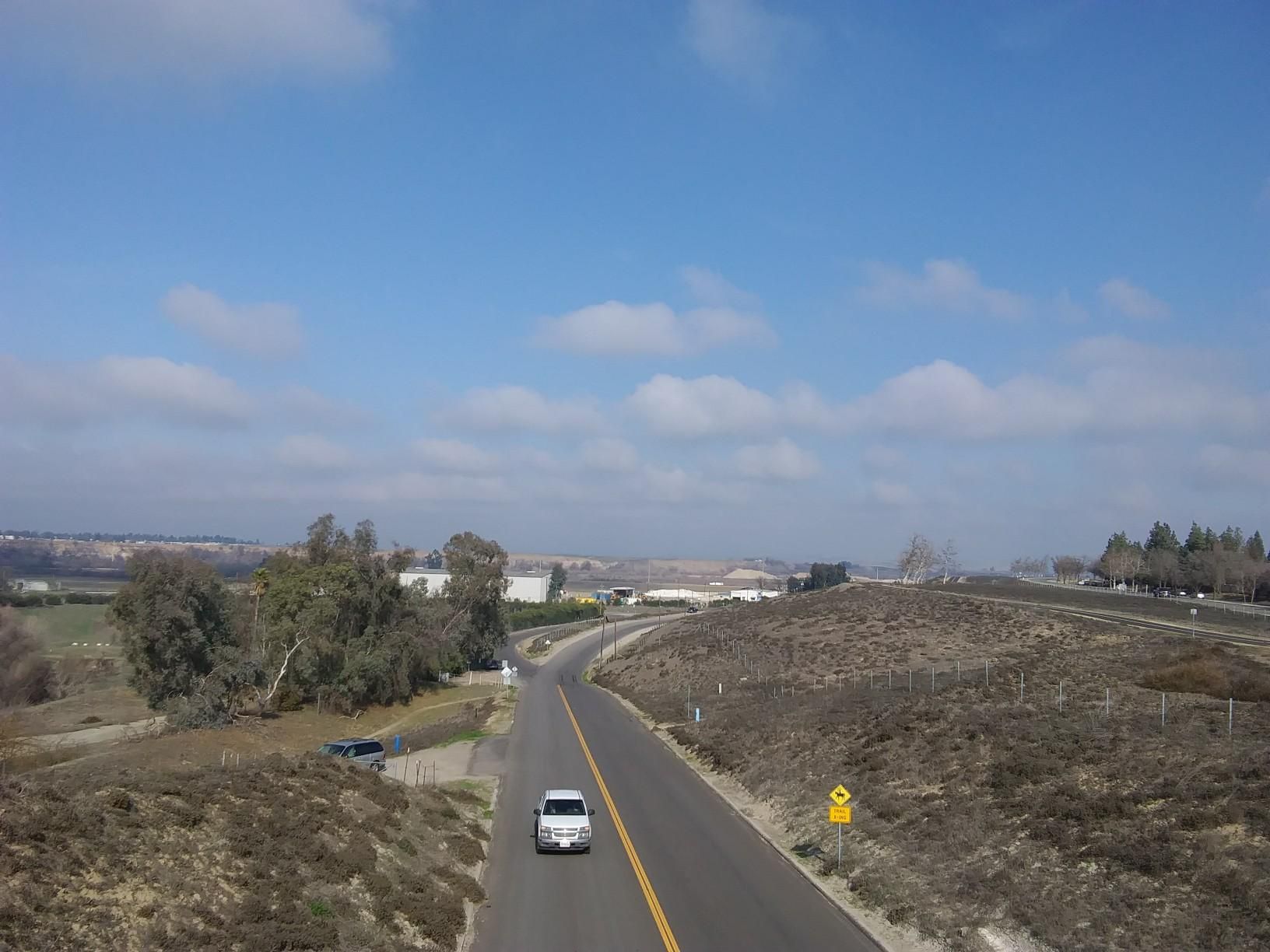 A white car on a winding road through dry hills under a sunny sky. - Lewis S. Eaton Bike Trail – Parkway Trust/Caglia loop from Parkway Trust / Caglia