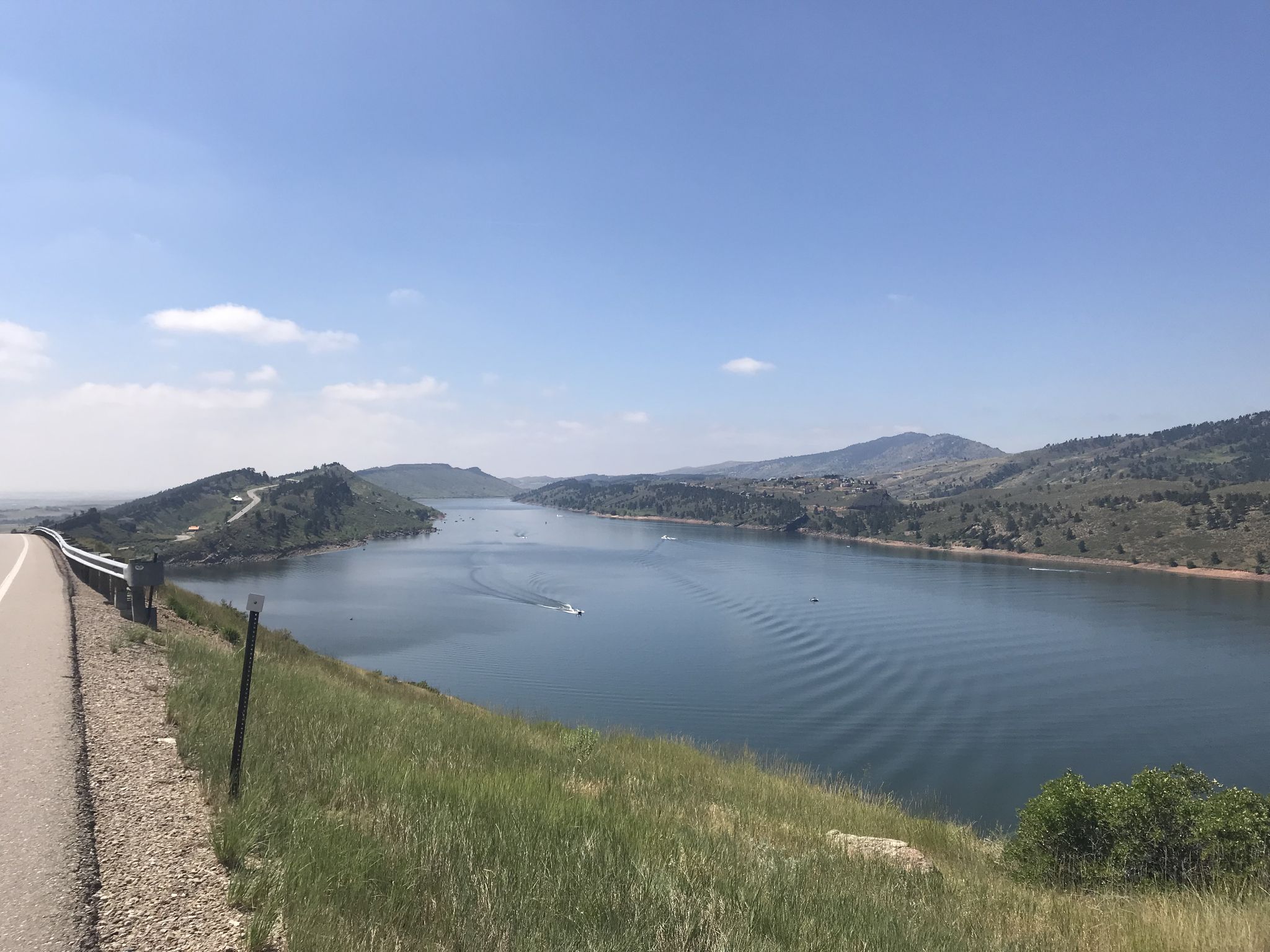 Wide lake with distant boats, surrounded by hills under a clear sky. - Skyline Picnic Area – Arthur's Rock Trailhead loop from Reservoir Ridge Natural Area