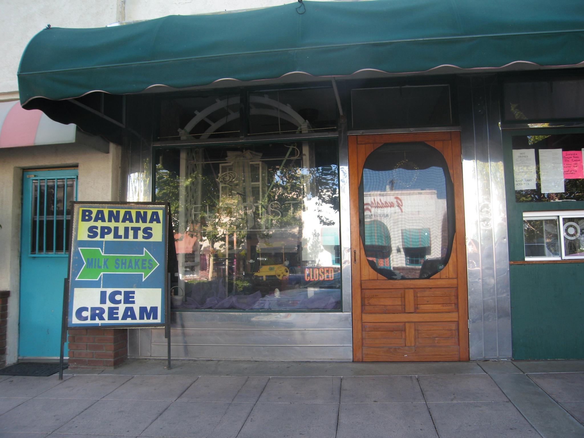Storefront with a green awning and a "Banana Splits Ice Cream" sign.