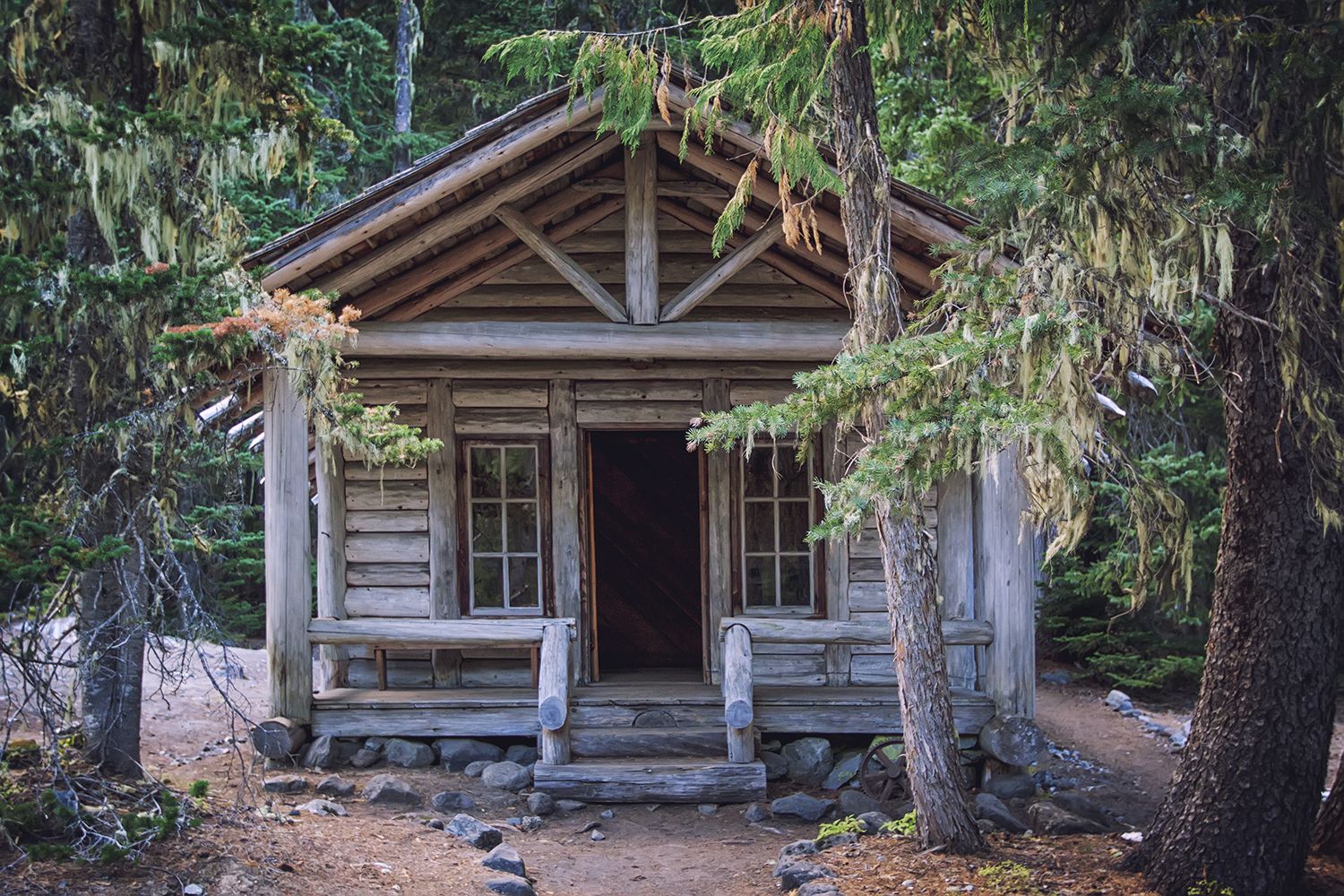 Rustic wooden cabin nestled among mossy trees in a dense forest. - White River Campground loop from Crystal Lake Trailhead