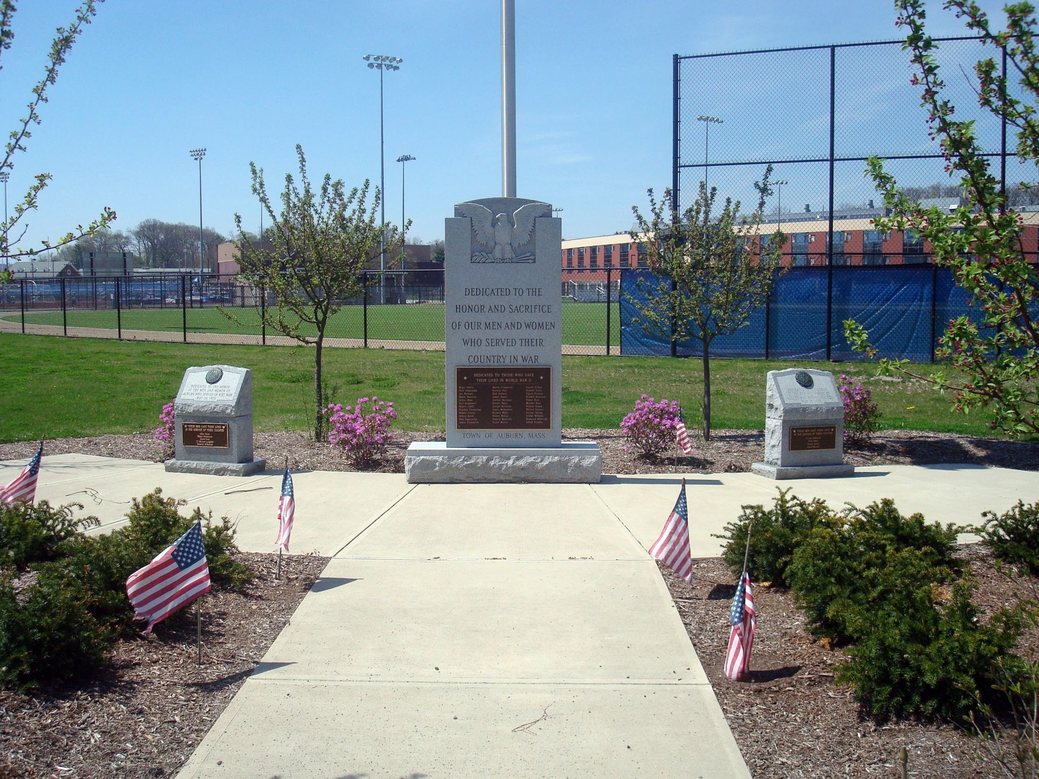 Stone monument with American flags on a sunny day near sports fields. - South Worcester to Singletary Pond loop via Auburn