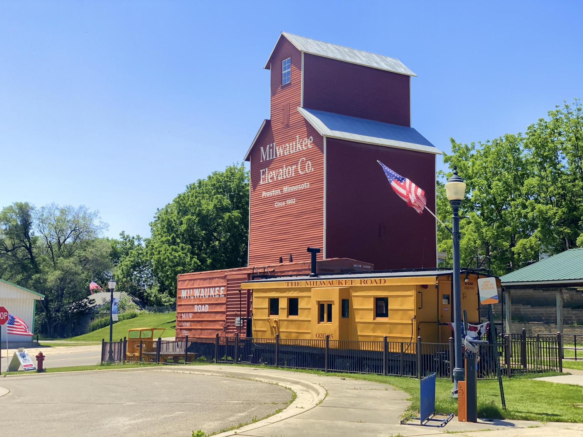 Red and yellow historic building with American flag under bright blue sky.