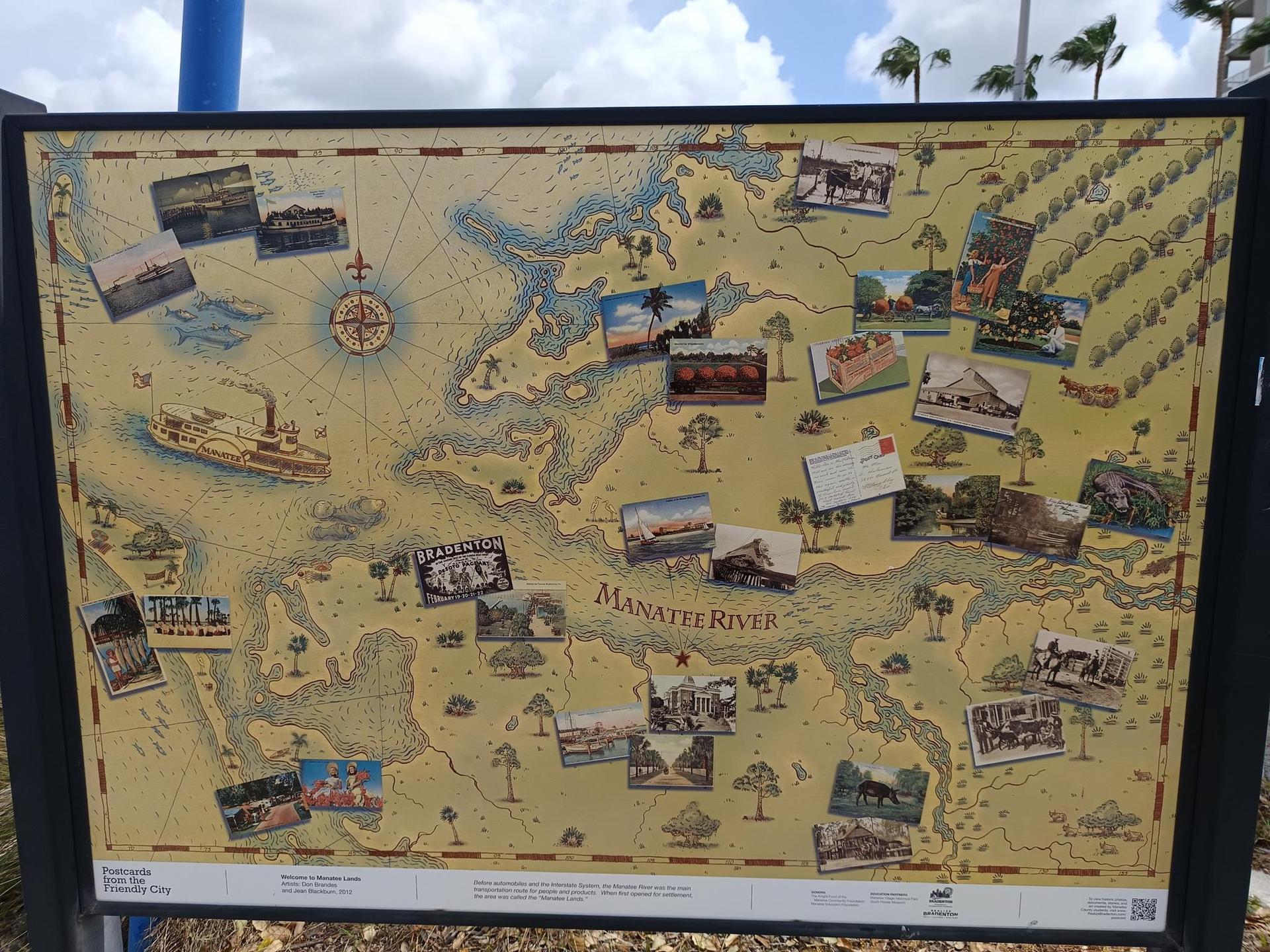 Large historical map display with numerous small photos under a bright, cloudy sky.