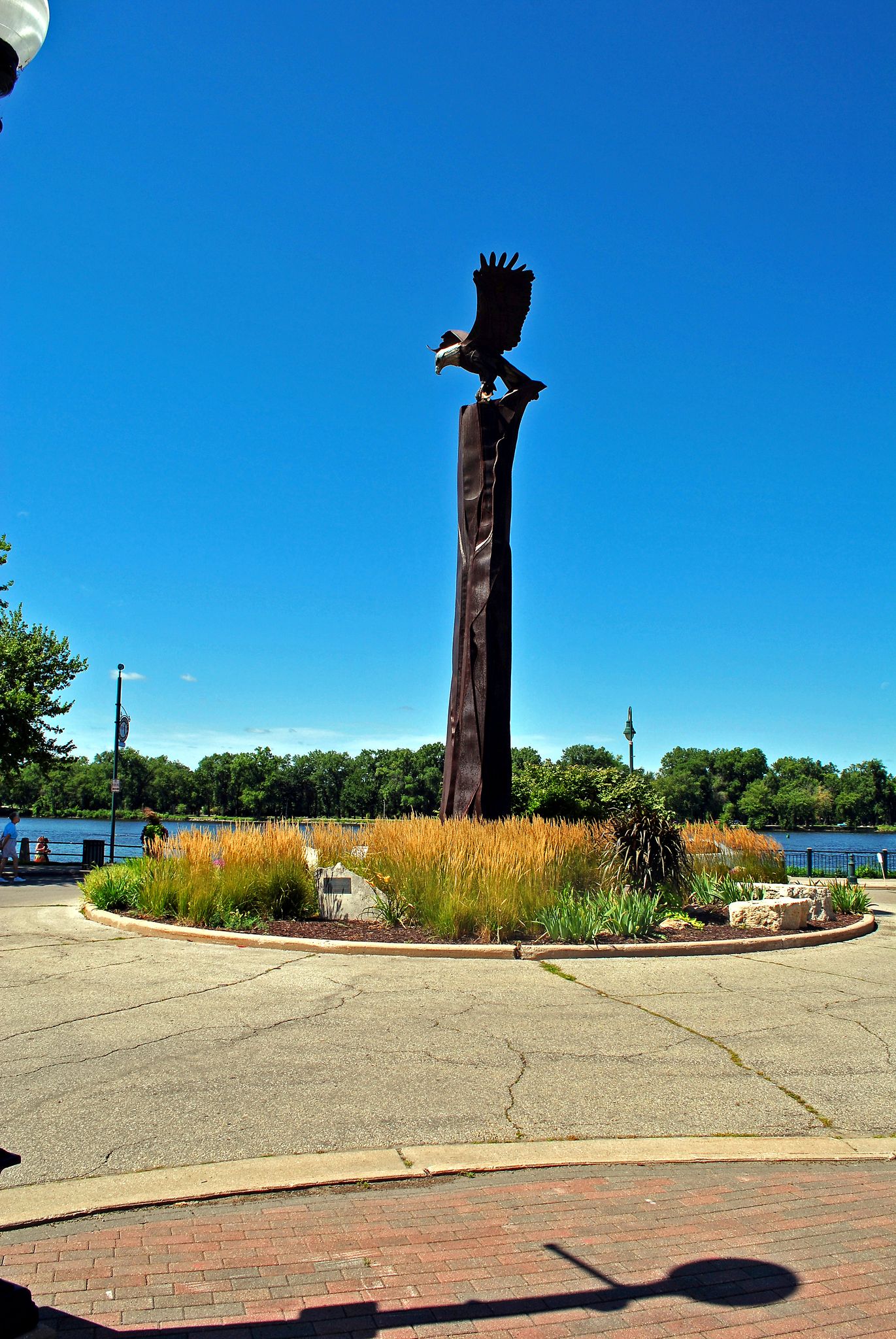 A large eagle statue on a tall pedestal under a clear blue sky. - A Triple Confluence of Rivers – Riverside Park loop from La Crosse