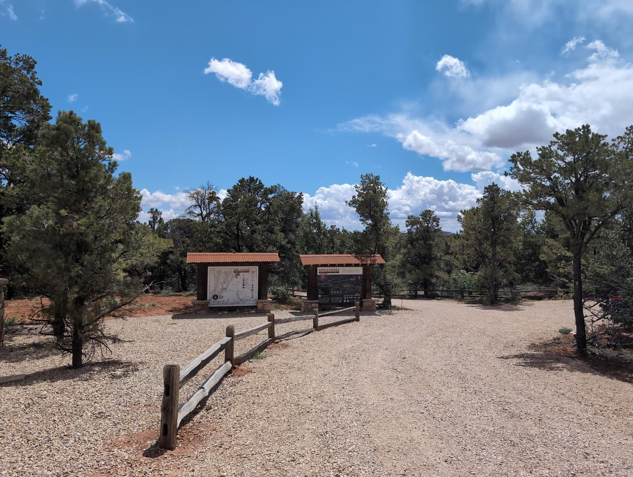 Two information kiosks beside a gravel path and trees on a sunny day. - Upper Applecross double loop via Elliptical Trail
