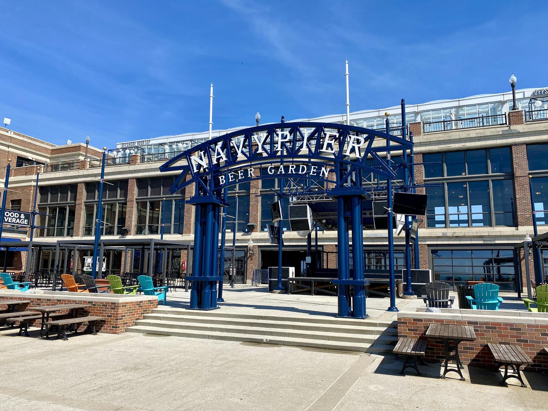 A blue archway entrance to an outdoor beer garden on a sunny day.