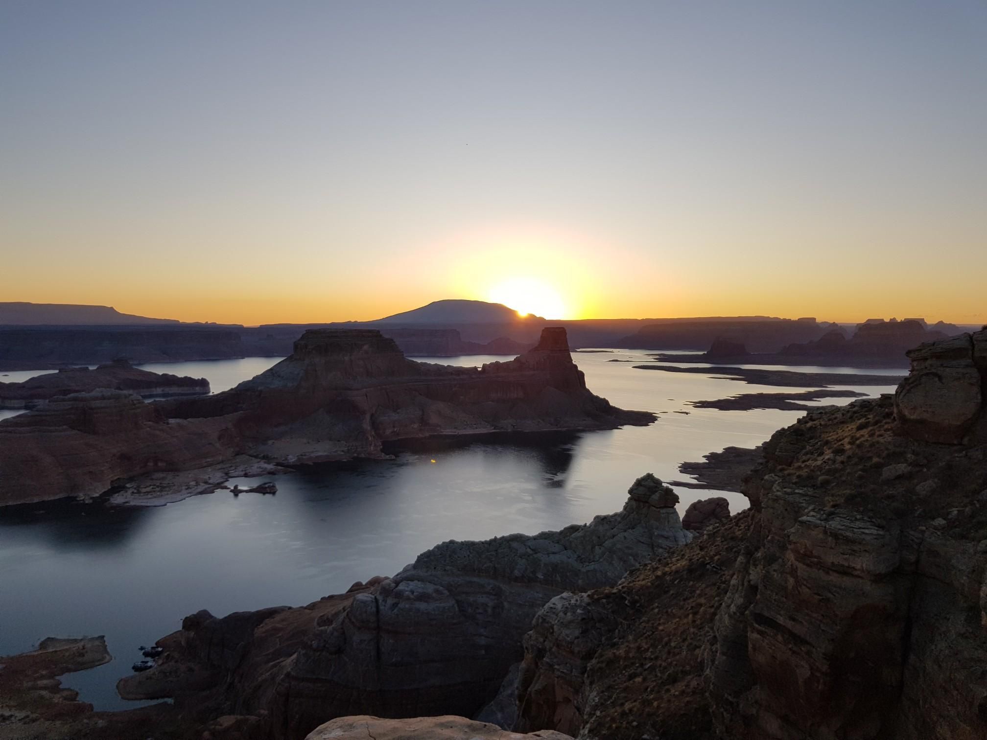 Scenic sunset over a large lake surrounded by rugged rock formations. - Alstrom Point via Smoky Mountain Road