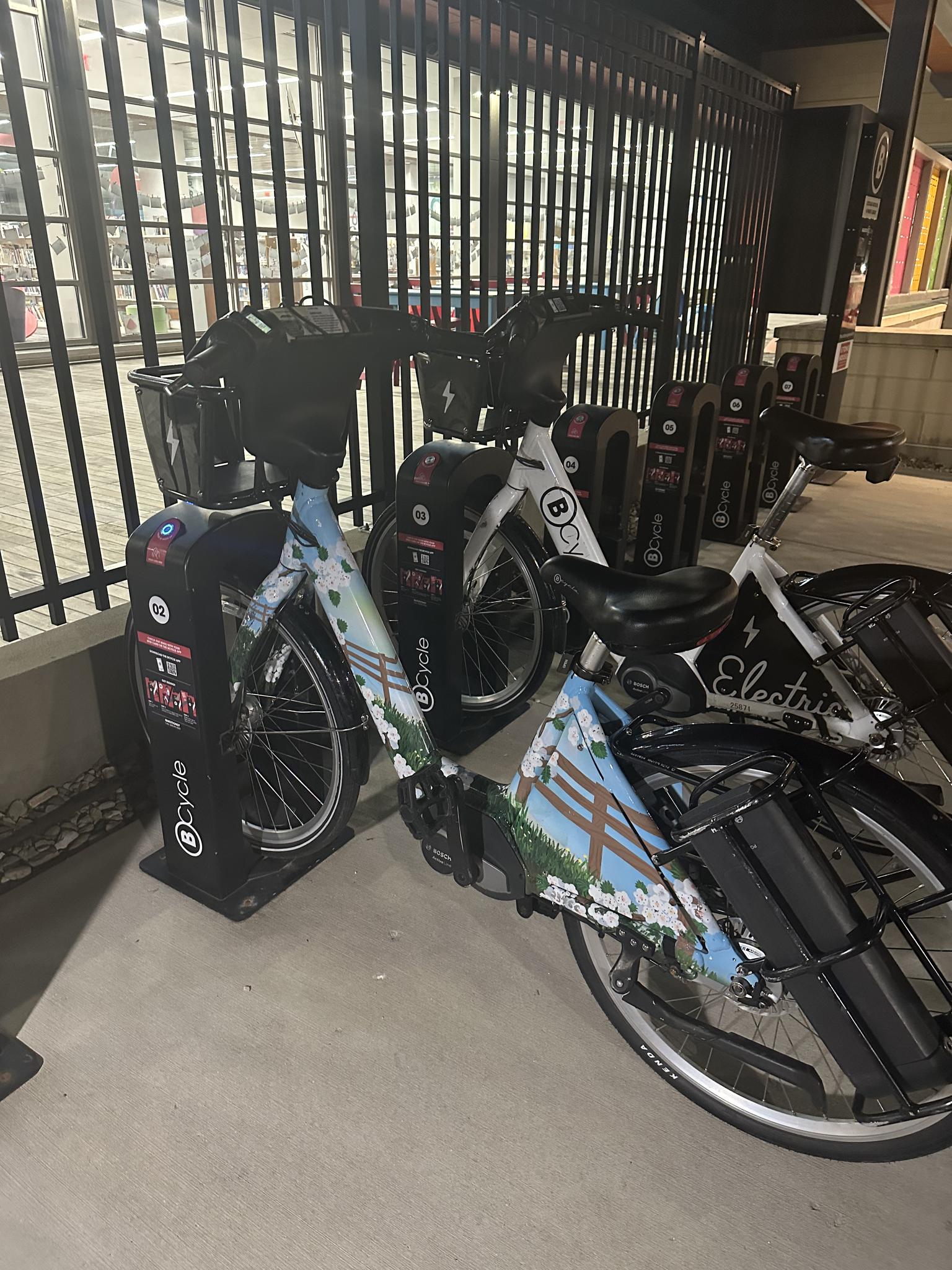 Bicycles parked at a bike share station at night.