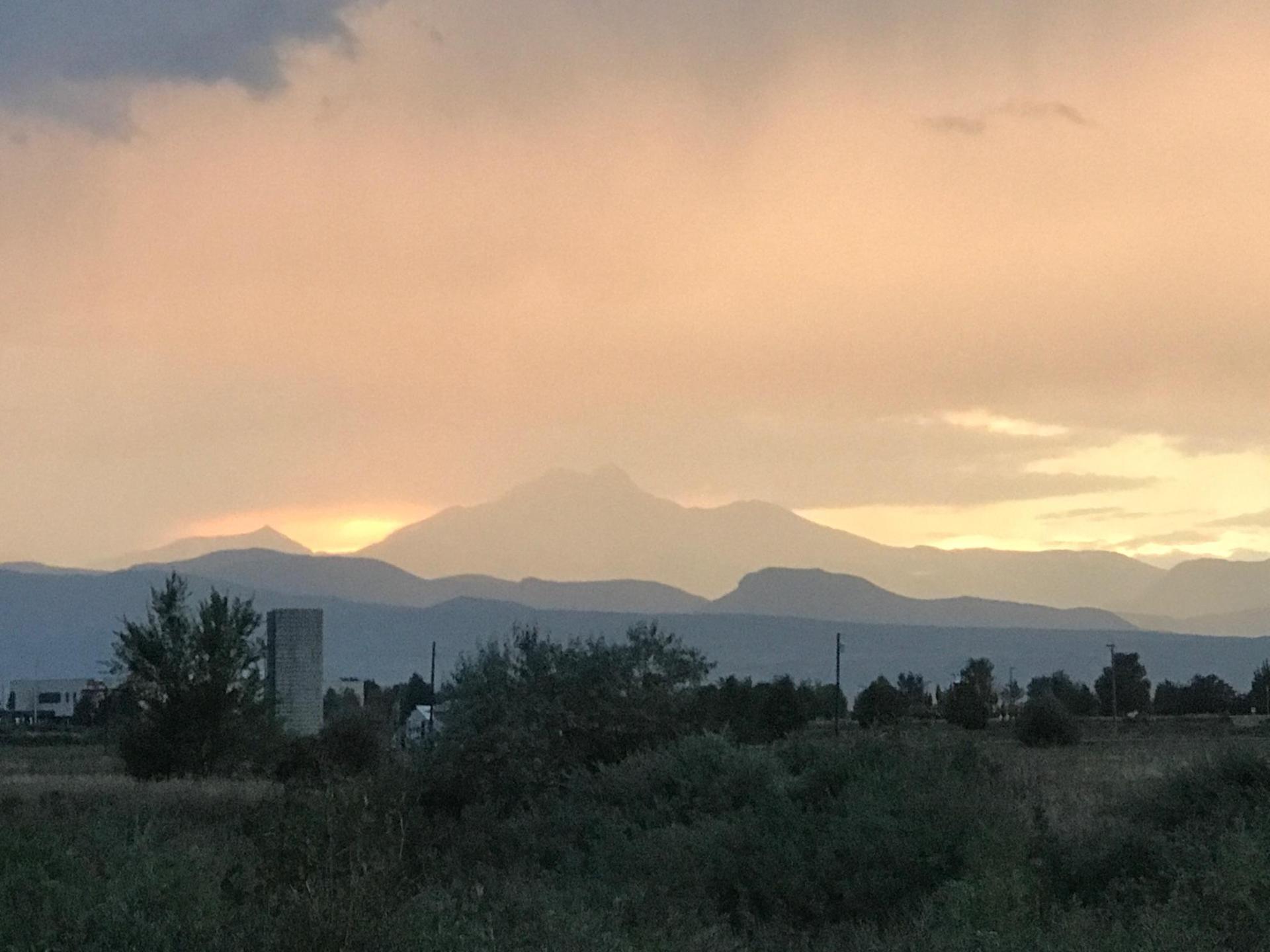 Distant mountains silhouetted against a golden, cloudy sunset sky.