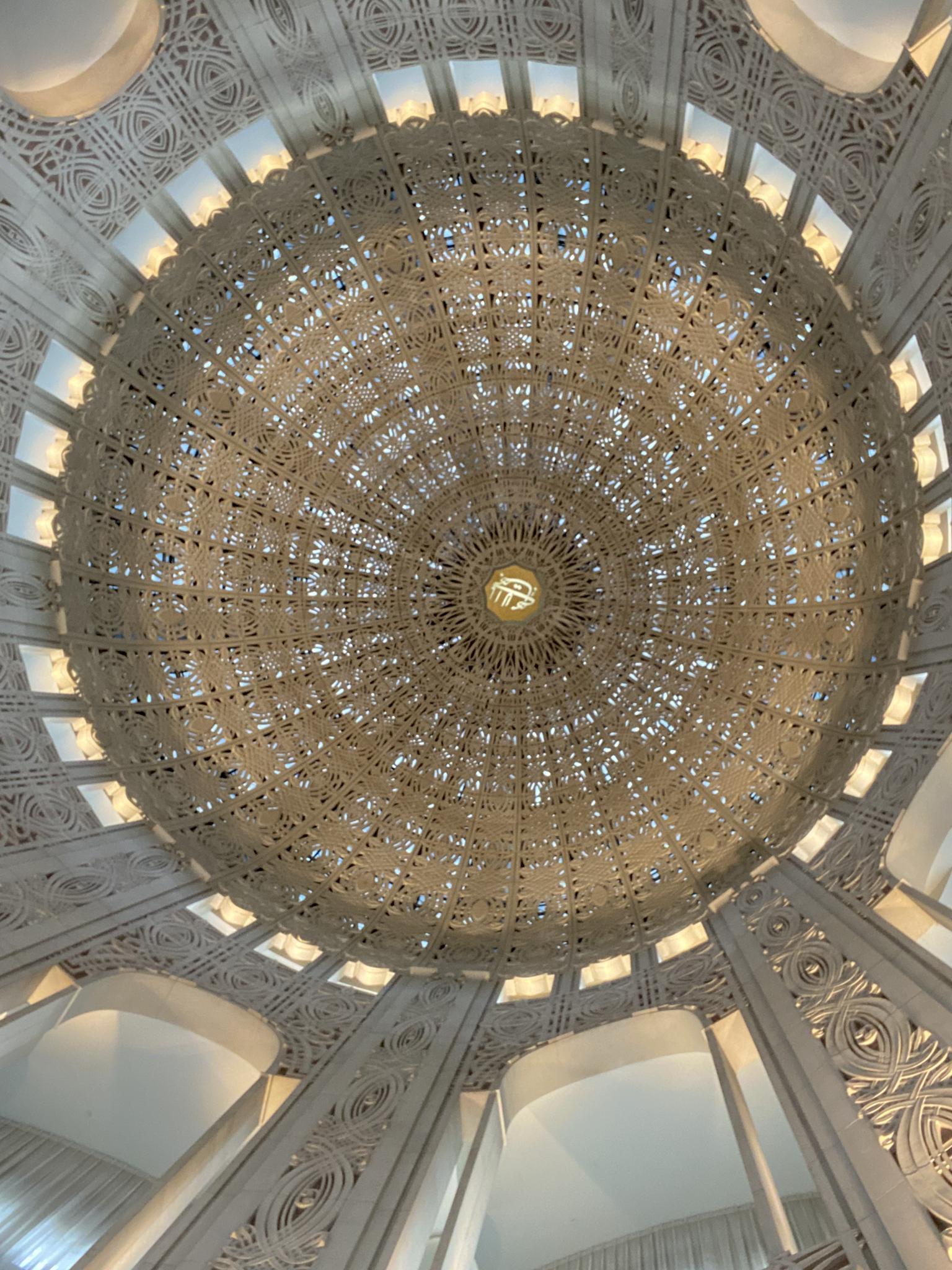 Intricate white dome ceiling with geometric patterns and soft lighting.