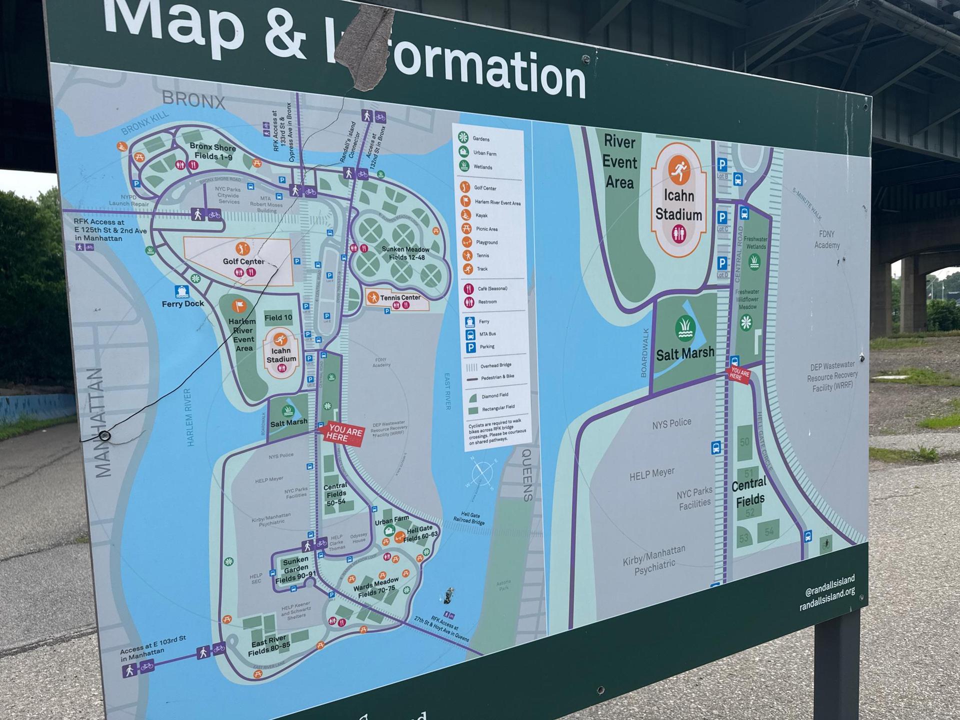 Large outdoor map and information sign with various icons.