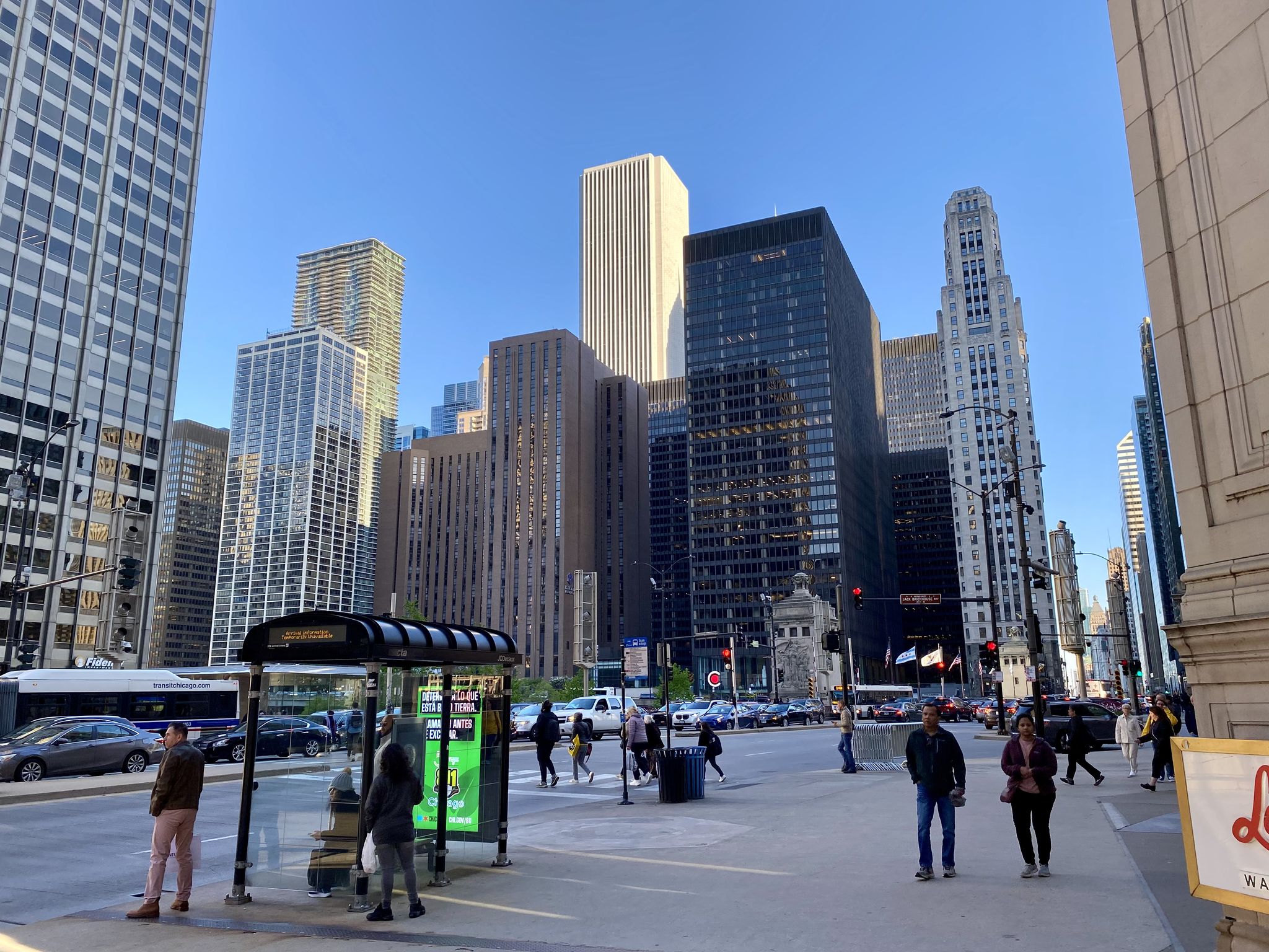 People on a sunny city street with tall buildings and traffic. - Magnificent Mile and Navy Pier Walk
