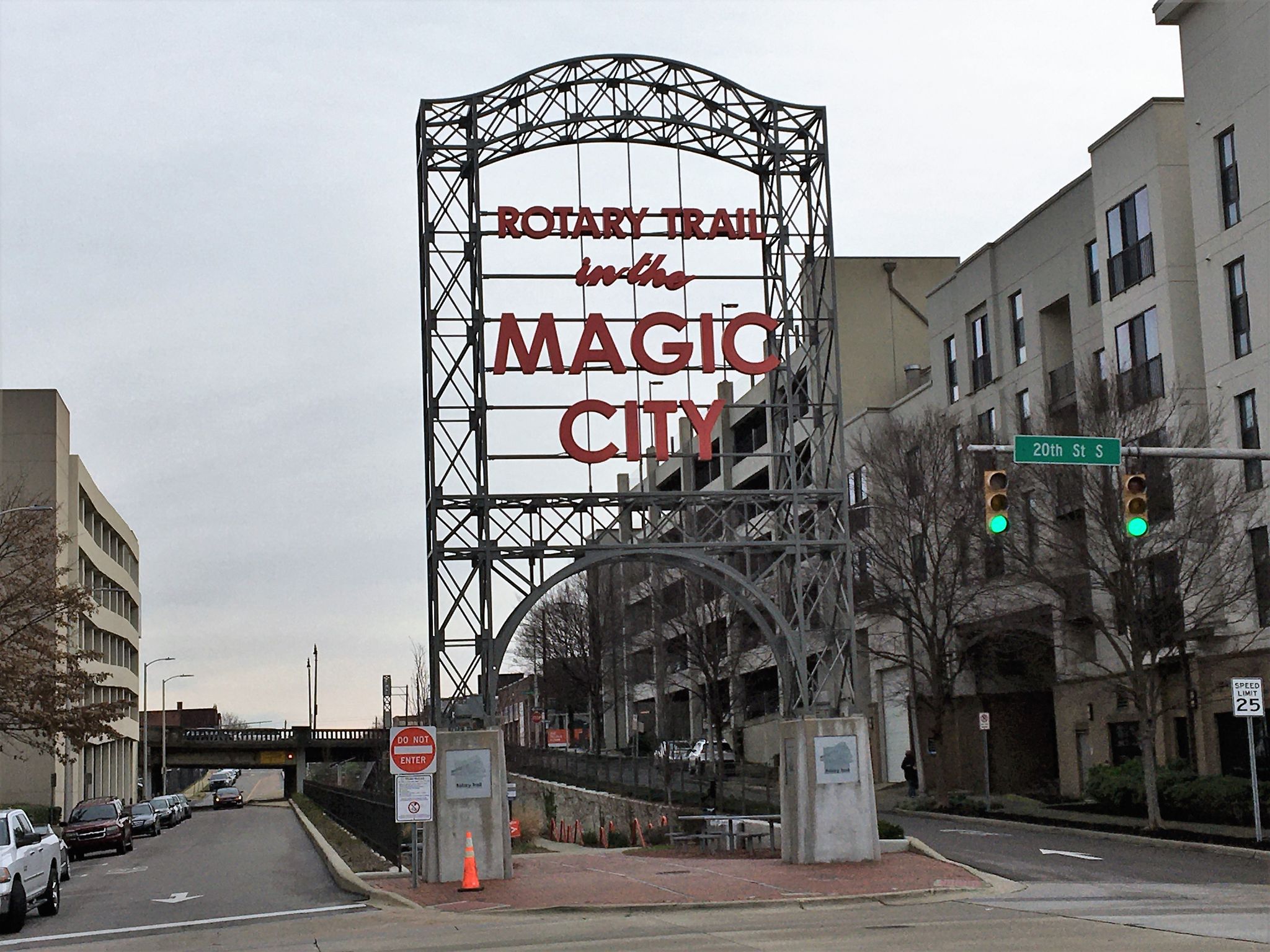 Large metal archway sign with red text over a street in an urban setting. - Running loop from Birmingham