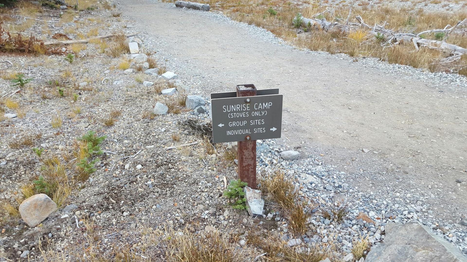 A brown sign on a gravel path points to 'Sunrise Camp' and 'Group Sites'.