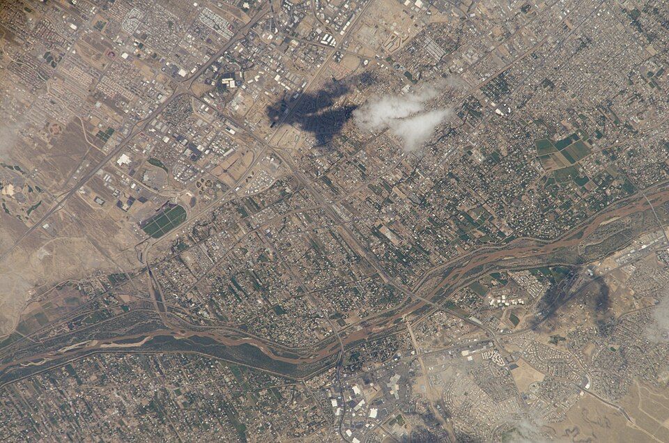 Overhead view of a sprawling city with a winding river and scattered clouds. - Bowl and Overlook Trail Loop