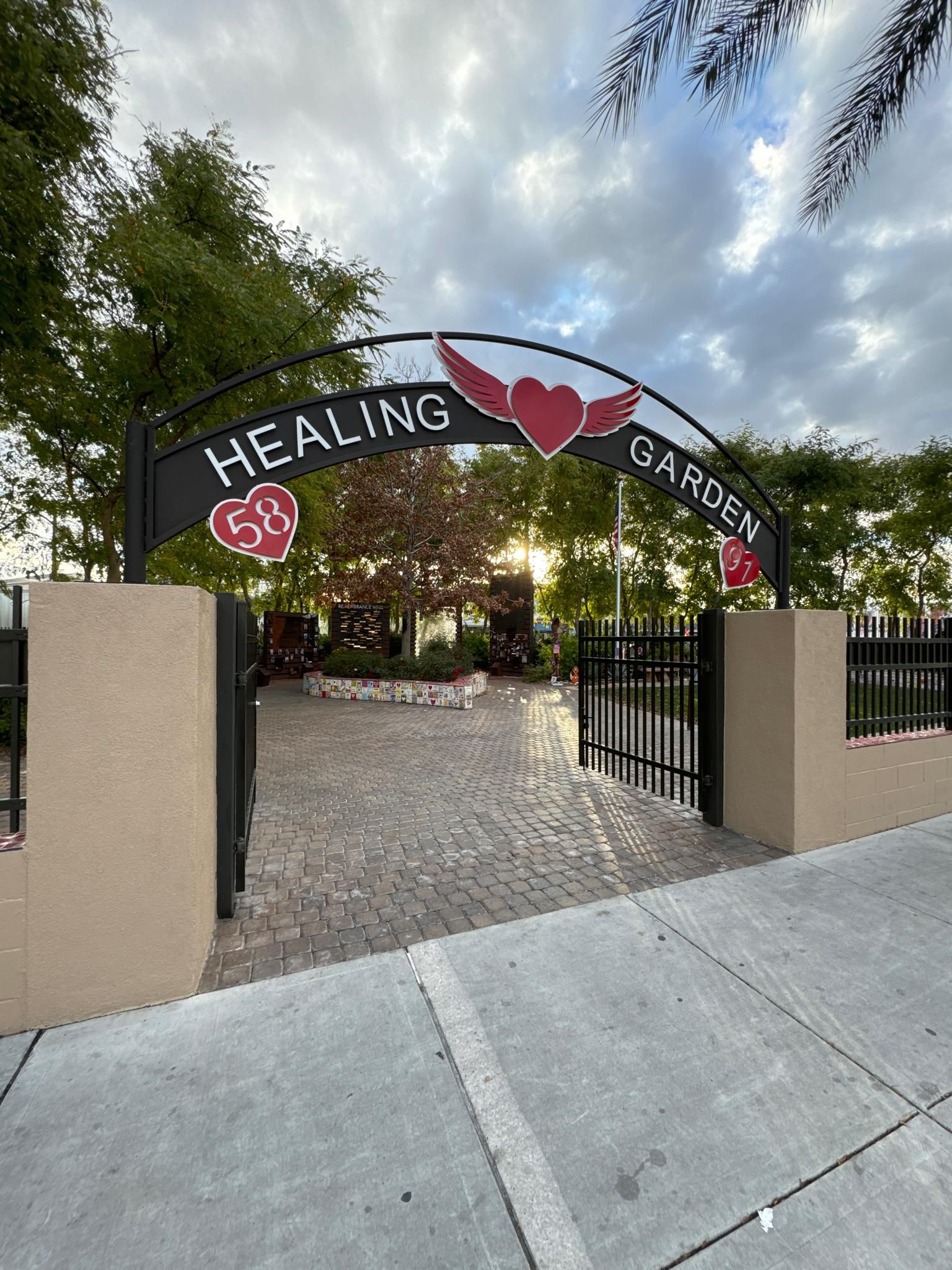 Arched 'HEALING GARDEN' gate with heart motifs under a cloudy sky. - Las Vegas Arts and Culture Walk