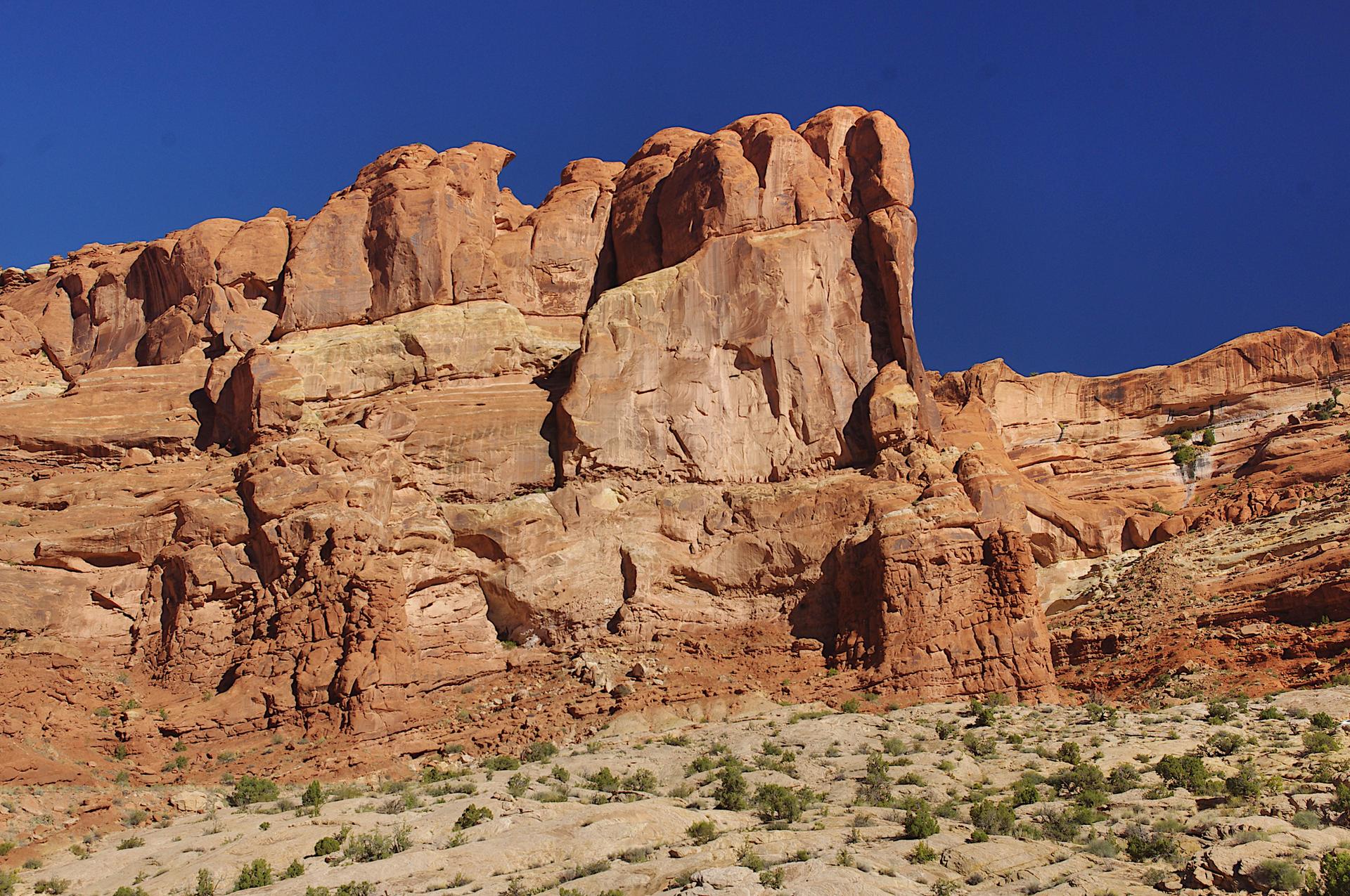 Towering red rock cliff formations under a clear blue sky.