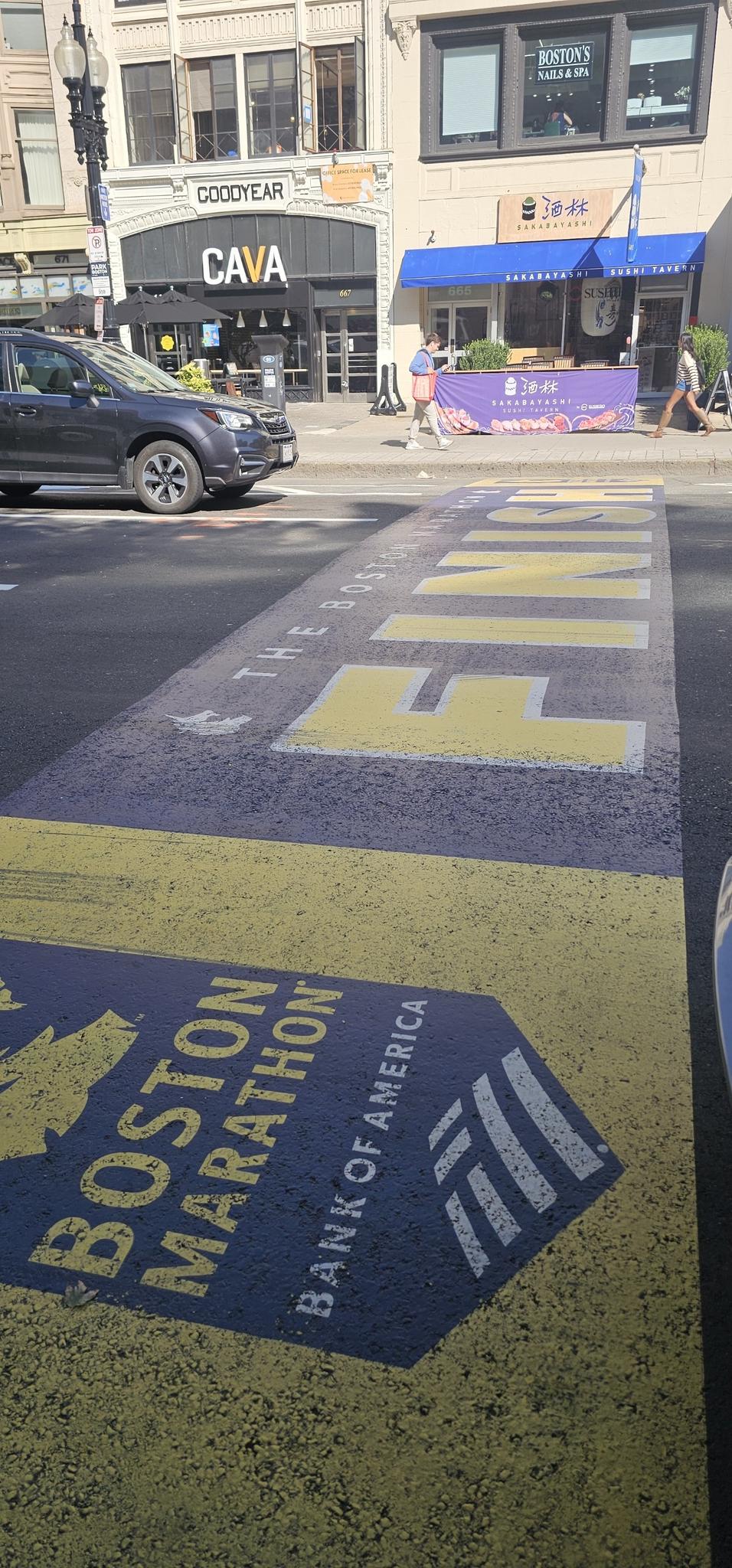 Yellow and blue street markings on asphalt in a sunny urban setting.