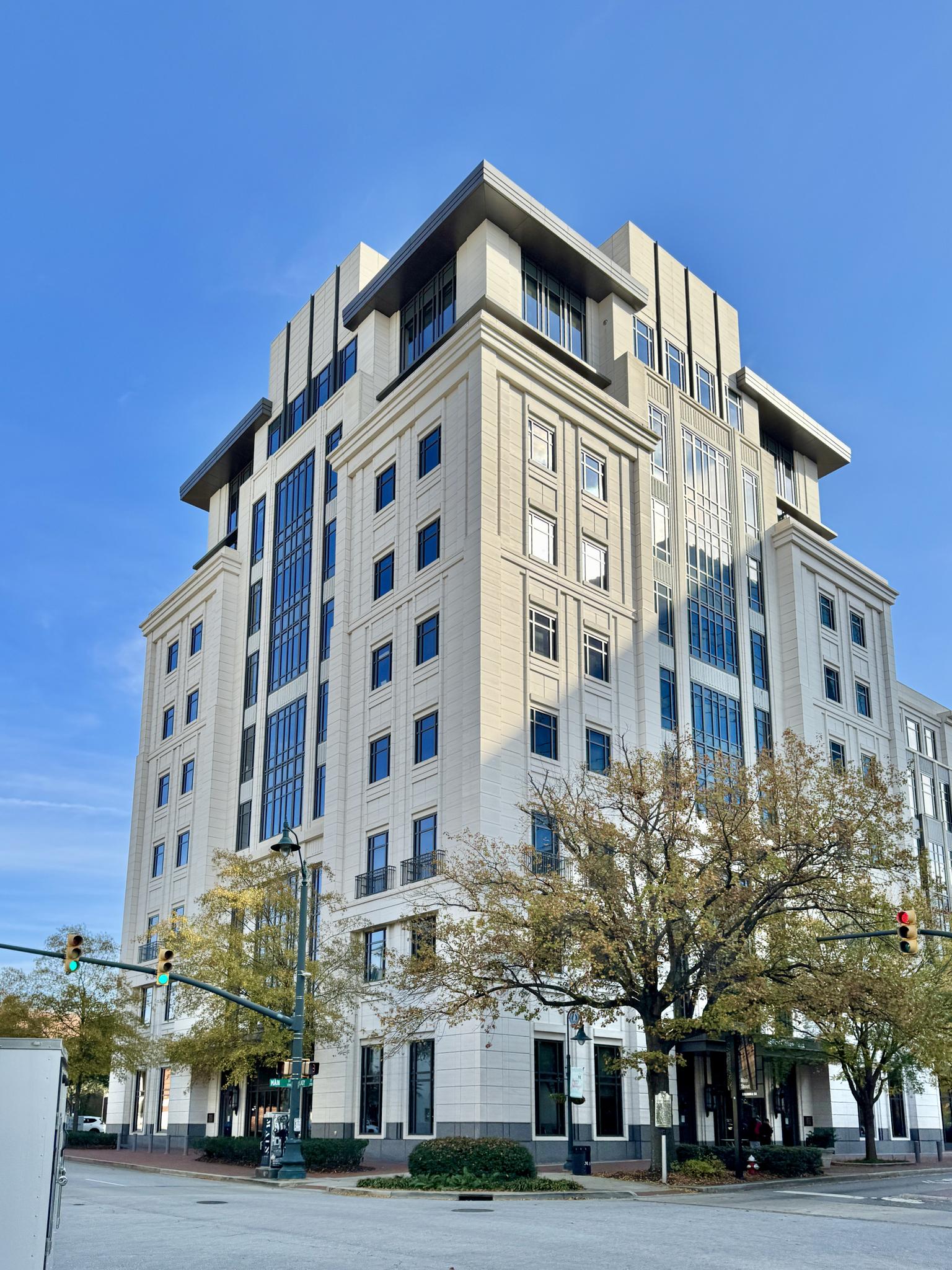 Tall, modern building with many windows under a clear blue sky.