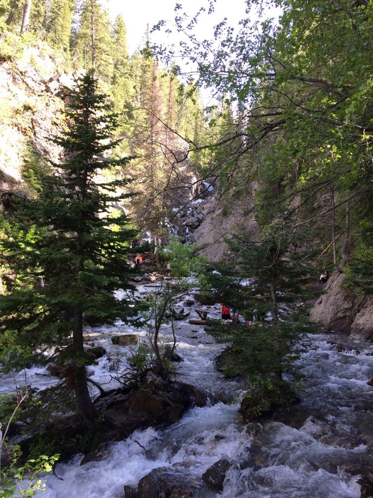 Rushing river in a forested canyon with people enjoying the sunny day. - Donut Falls loop from Big Cottonwood Creek