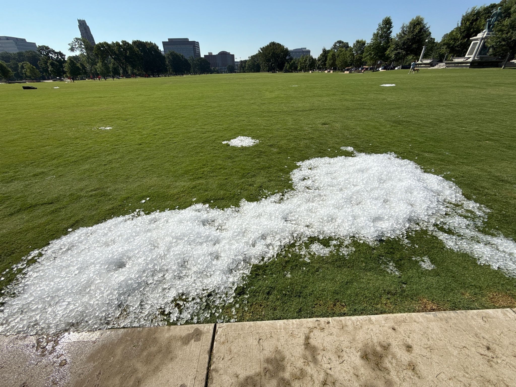 Piles of white ice cover a bright green grassy field under clear skies. - Centennial Park – The Parthenon (Nashville) loop from Vanderbilt University