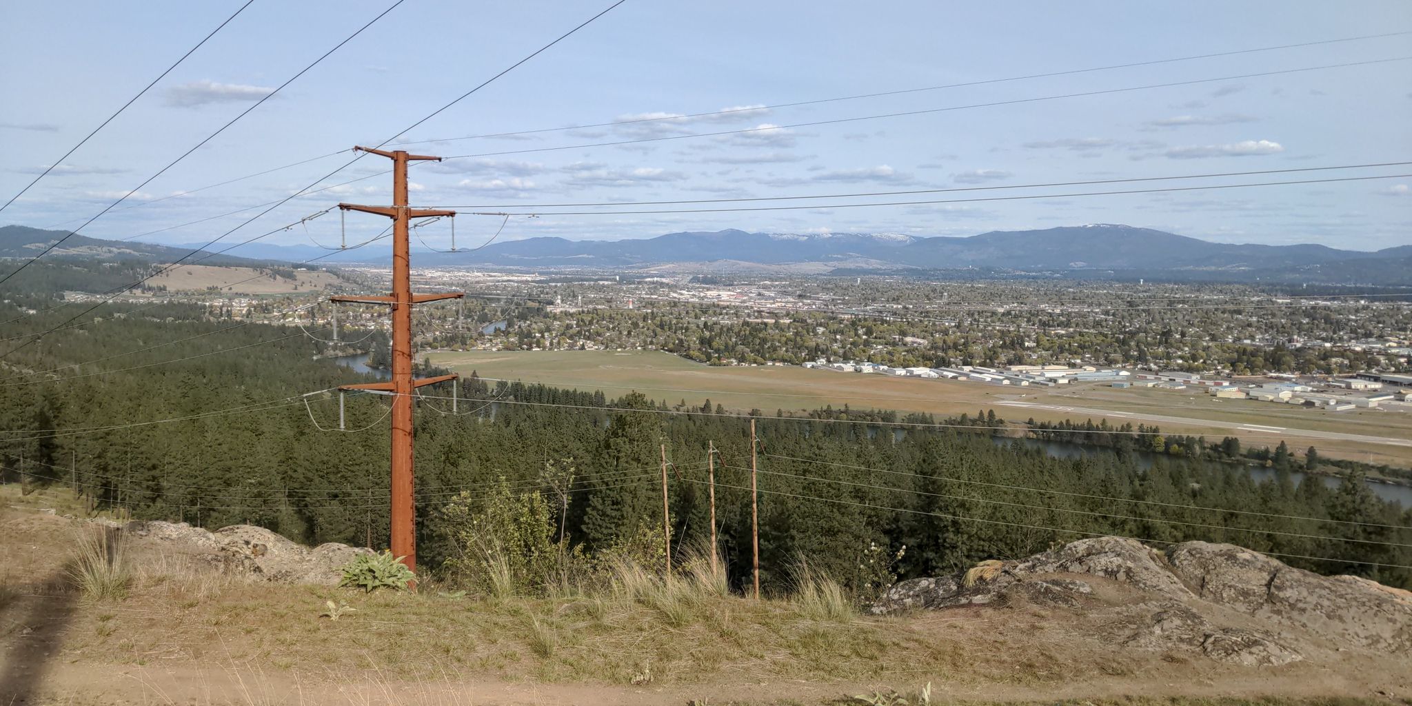 A large power pole stands overlooking a city and river valley. - Beacon Hill – Camp Sekani Conservation Area loop from Spokane Community College