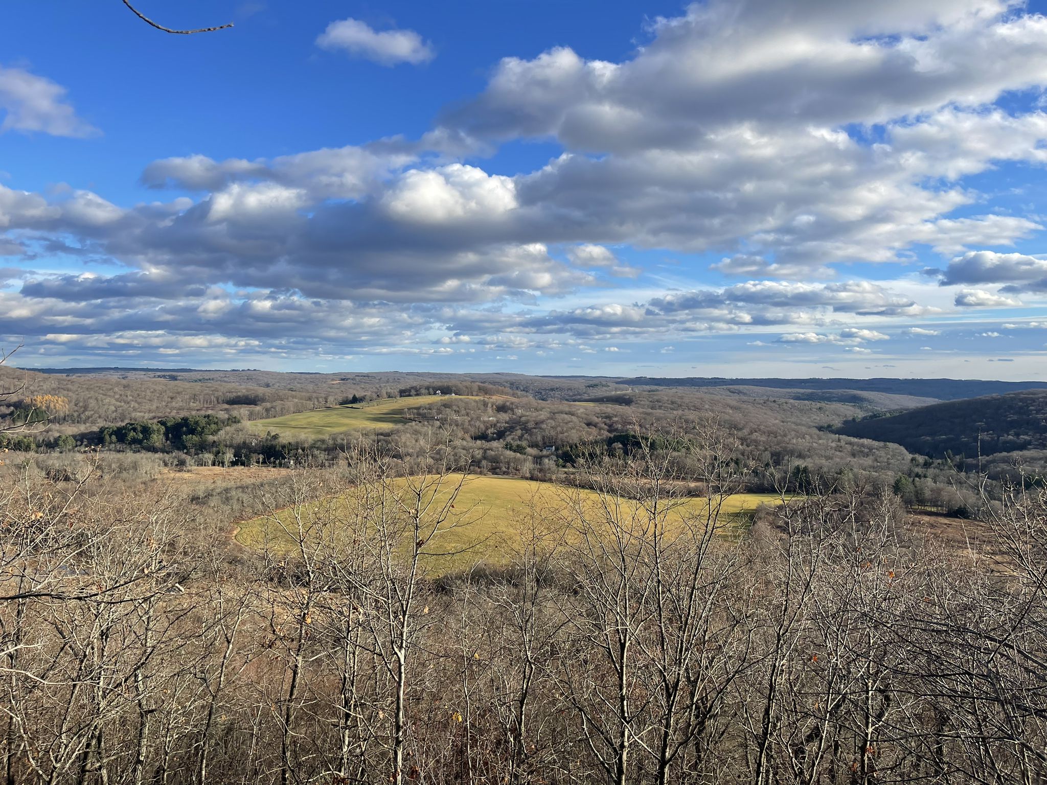 Panoramic view of rolling hills with bare trees and green fields under a cloudy sky. - Macricostas Preserve loop from New Preston