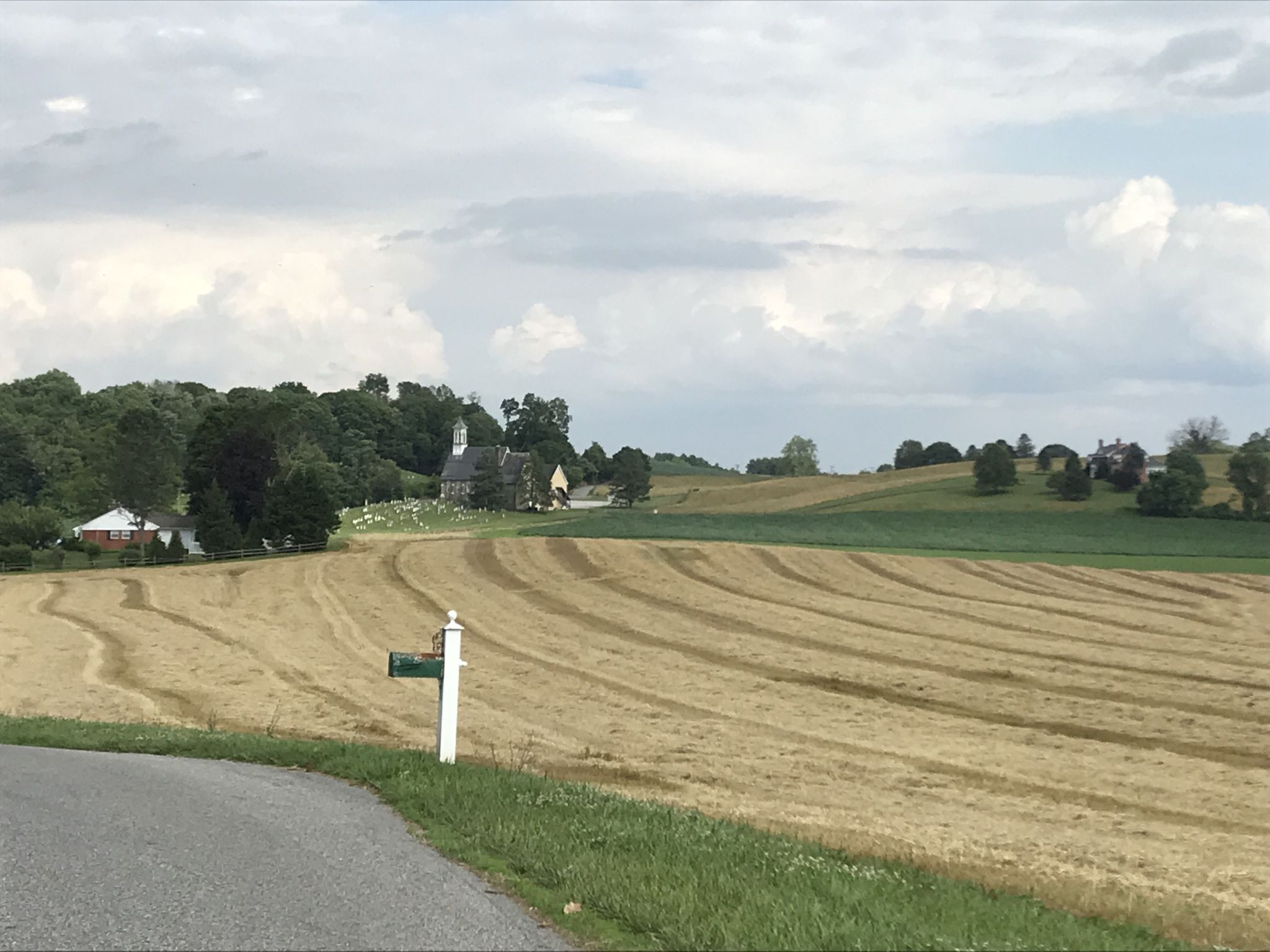 Rural landscape with harvested fields, distant church, and cloudy sky. - Nice view of Bosley Church loop from Butler
