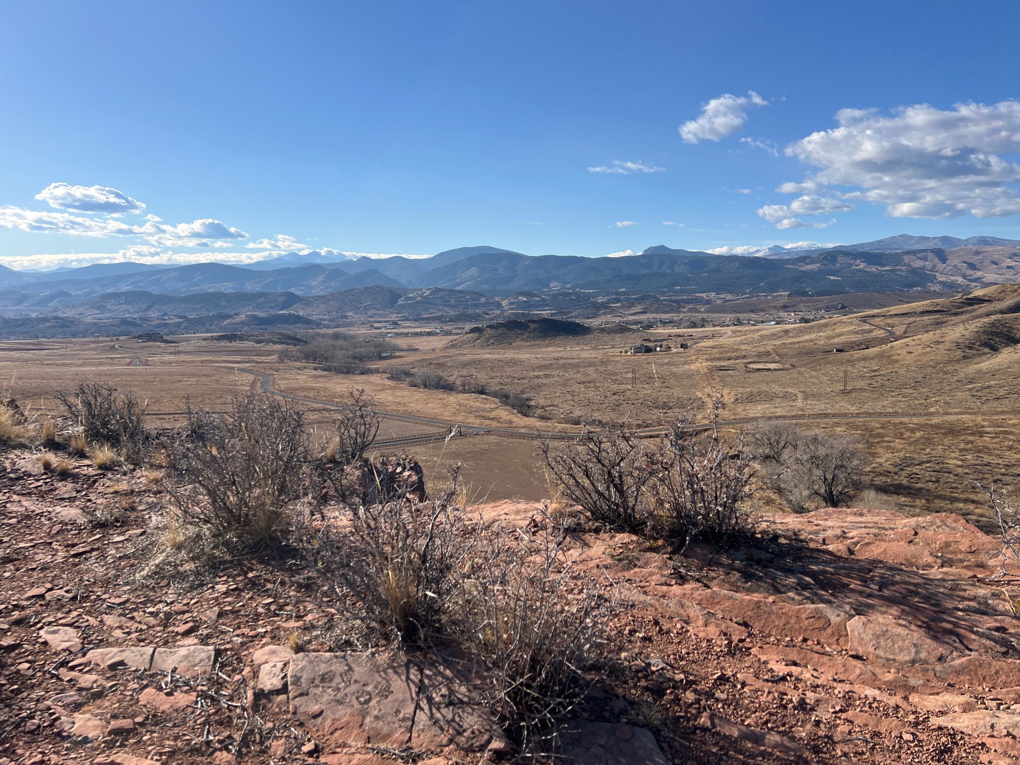 Expansive view of dry, hilly landscape with distant mountains under blue sky. - Devils Backbone Open Space – Blue Sky Trail viewpoint loop from Loveland Transit Center