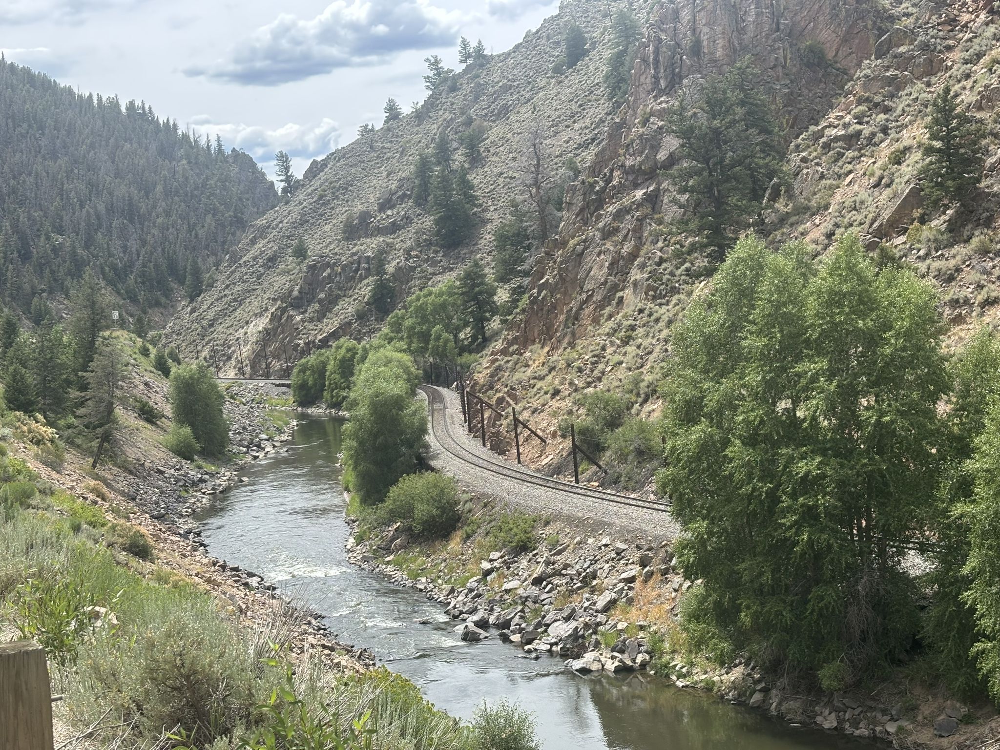 River and railroad tracks winding through a steep, rocky, forested canyon. - Fraser River Trail – Byers Canyon loop from Fraser-Winter Park