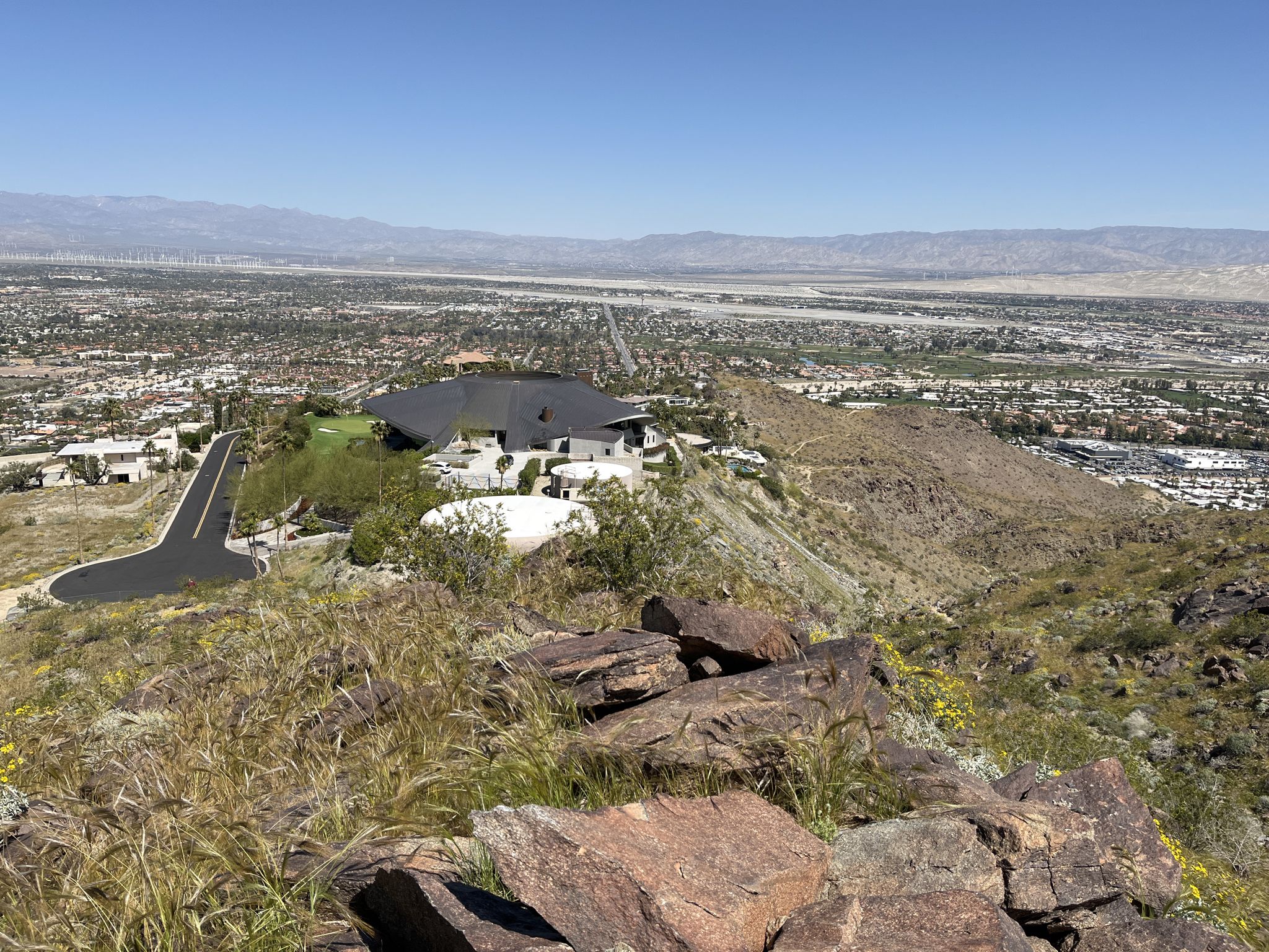 Modern house on a rocky hill overlooking a sunny valley city. - Araby Trail loop from Prescott Preserve