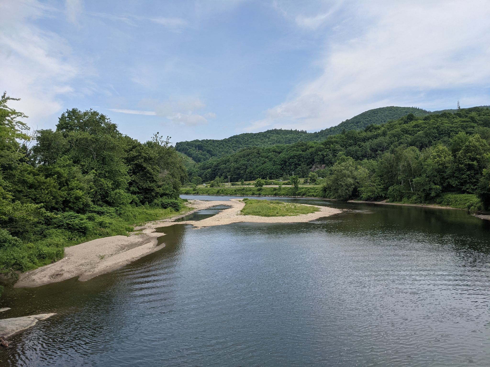 Wide river with sandy banks, green forested hills under a partly cloudy sky. - Cross Vermont Trail