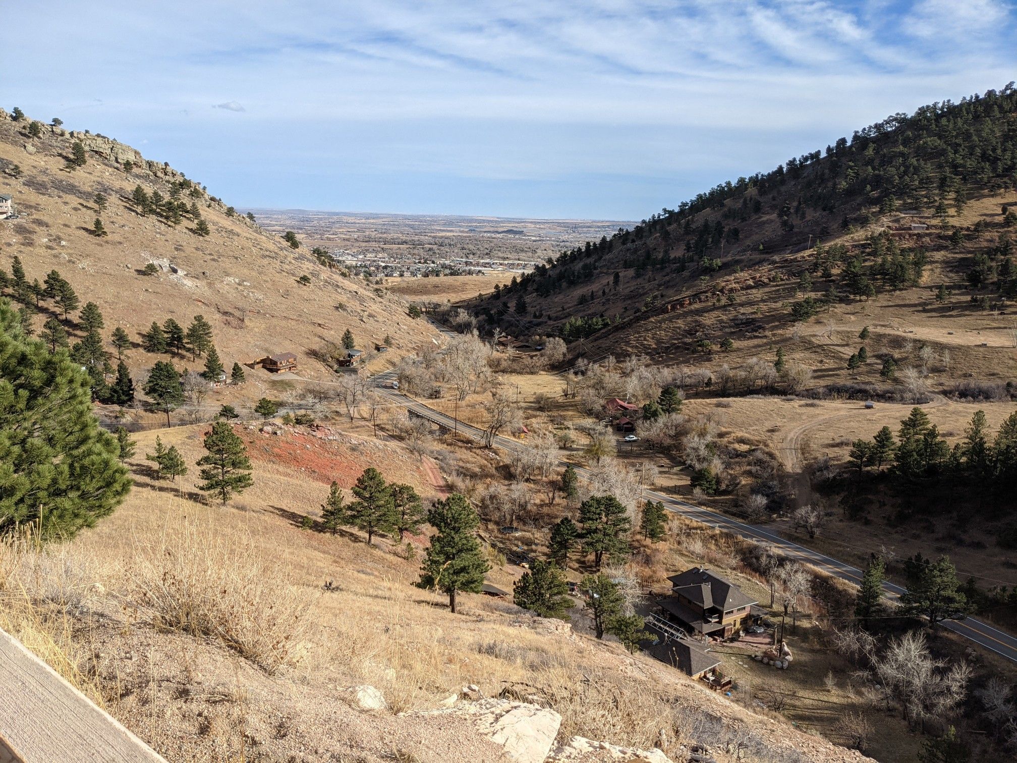 An aerial view of a valley with dry hills, scattered trees, and distant buildings. - Niwot and Nelson Roads, Lefthand Canyon, and Olde Stage loop