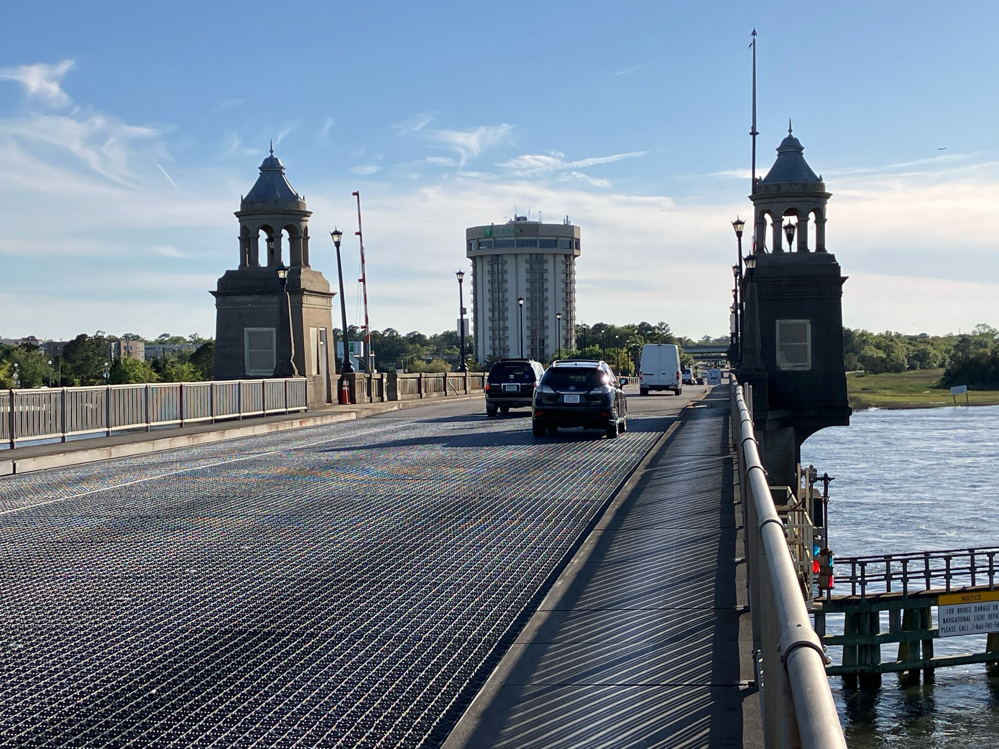 Cars driving on a bridge with ornate towers under a bright blue sky. - Stono River loop
