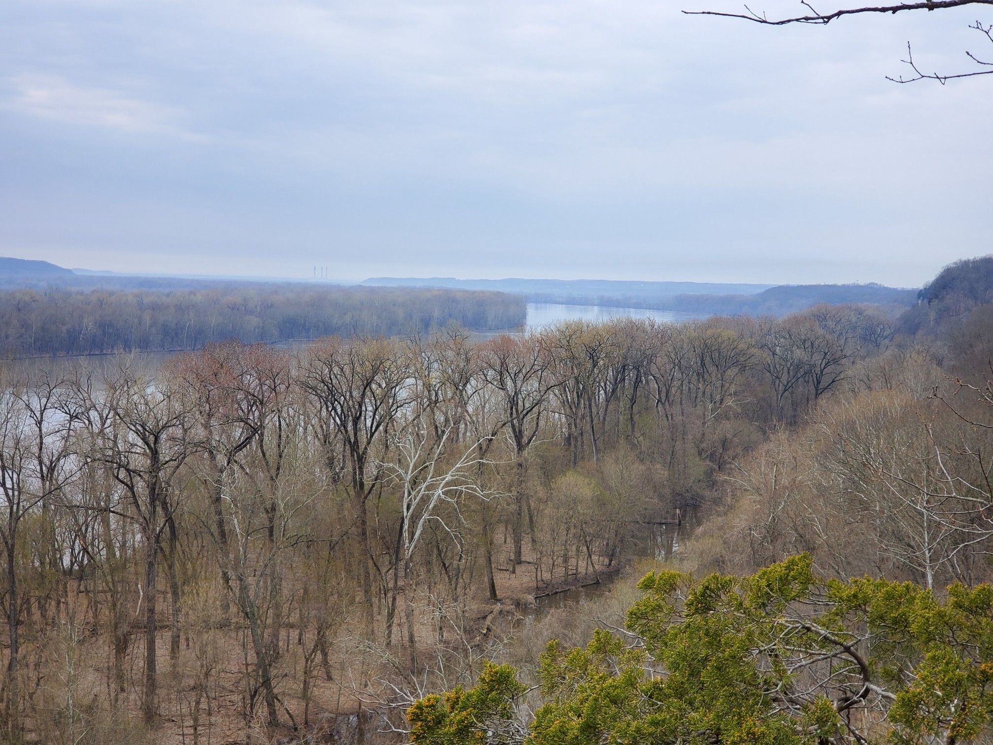Overcast view of a wide river winding through a valley of bare winter trees. - Lewis and Clark Trail Loop